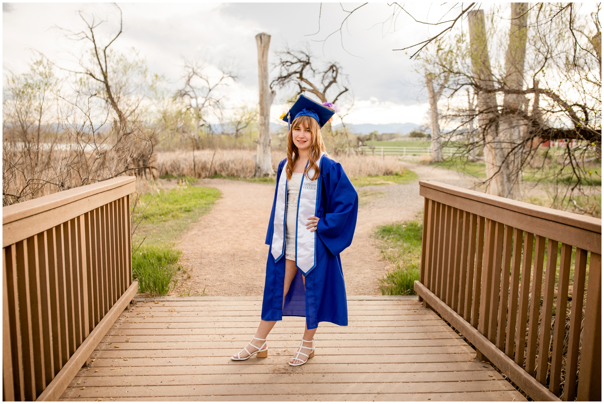 teen posing on bridge during Colorado cap and gown graduation session at McKay Lake