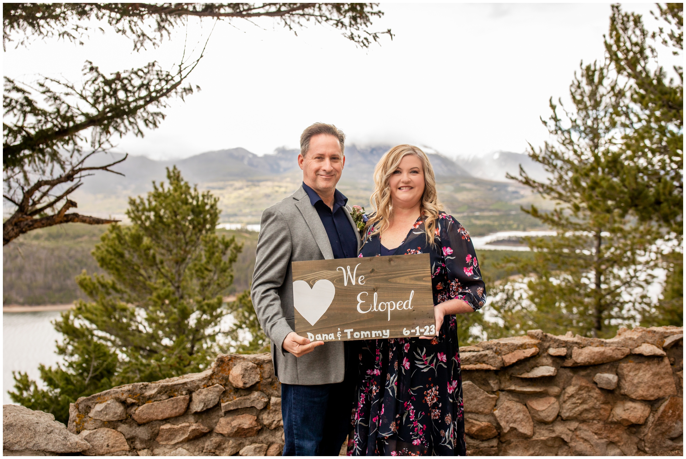 couple holding elopement sign at Sapphire Point Overlook in Colorado mountains 