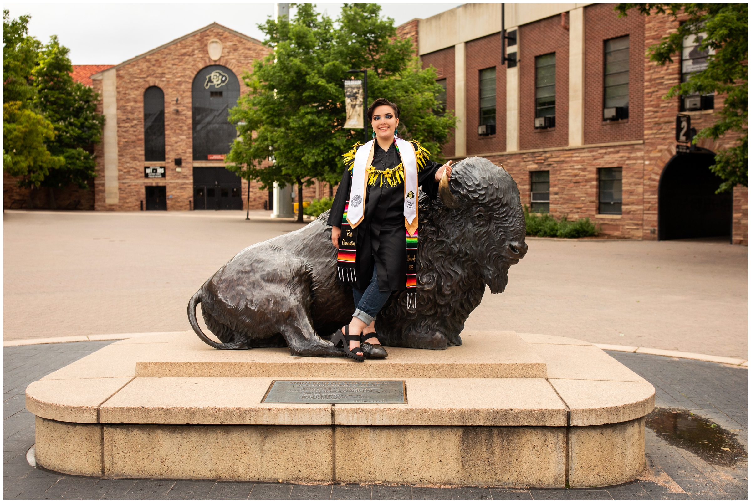 woman posing with buffalo sculpture at CU Boulder during college senior portraits in Colorado 