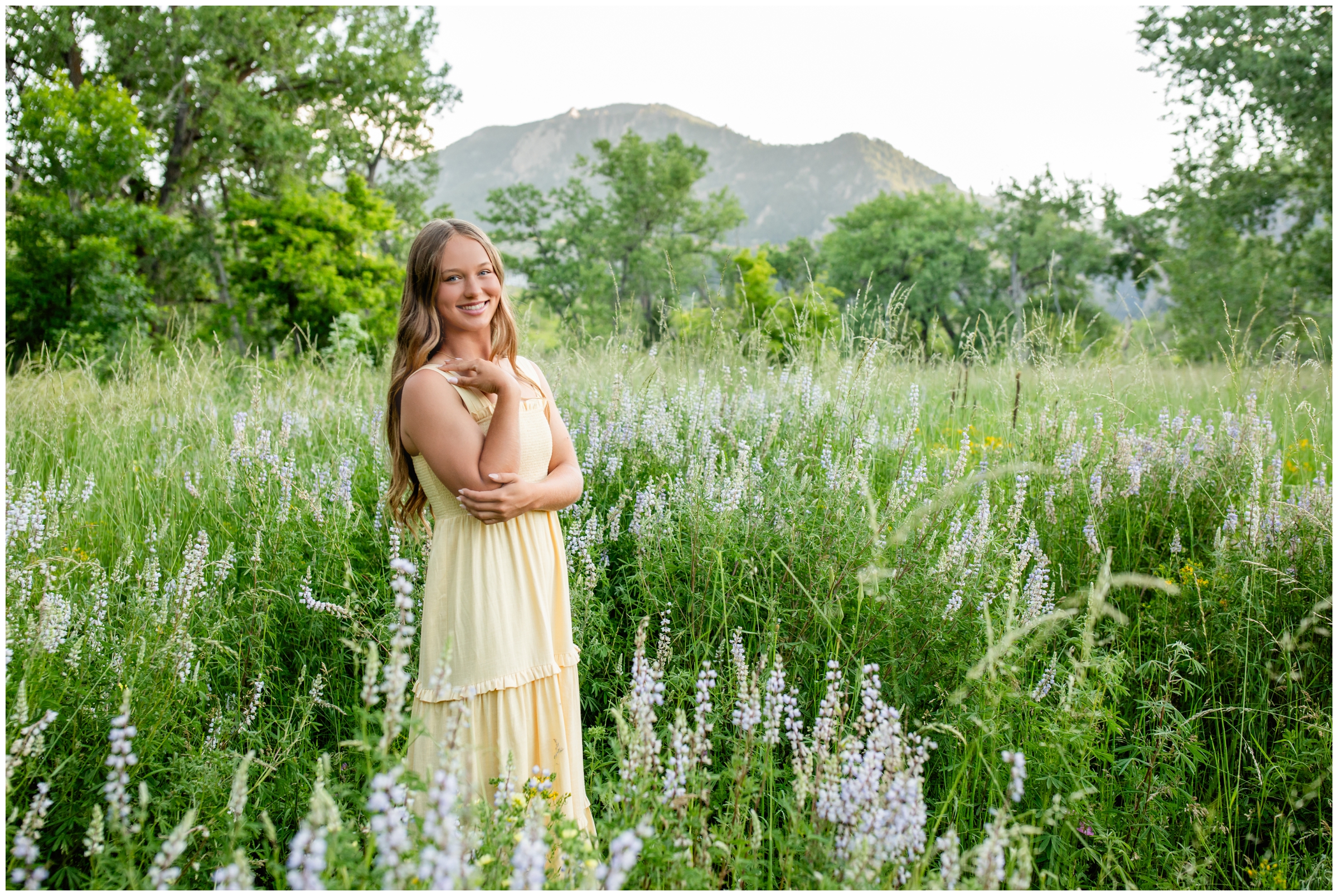 teen posing in wildflower field in Colorado mountains during Boulder senior pictures