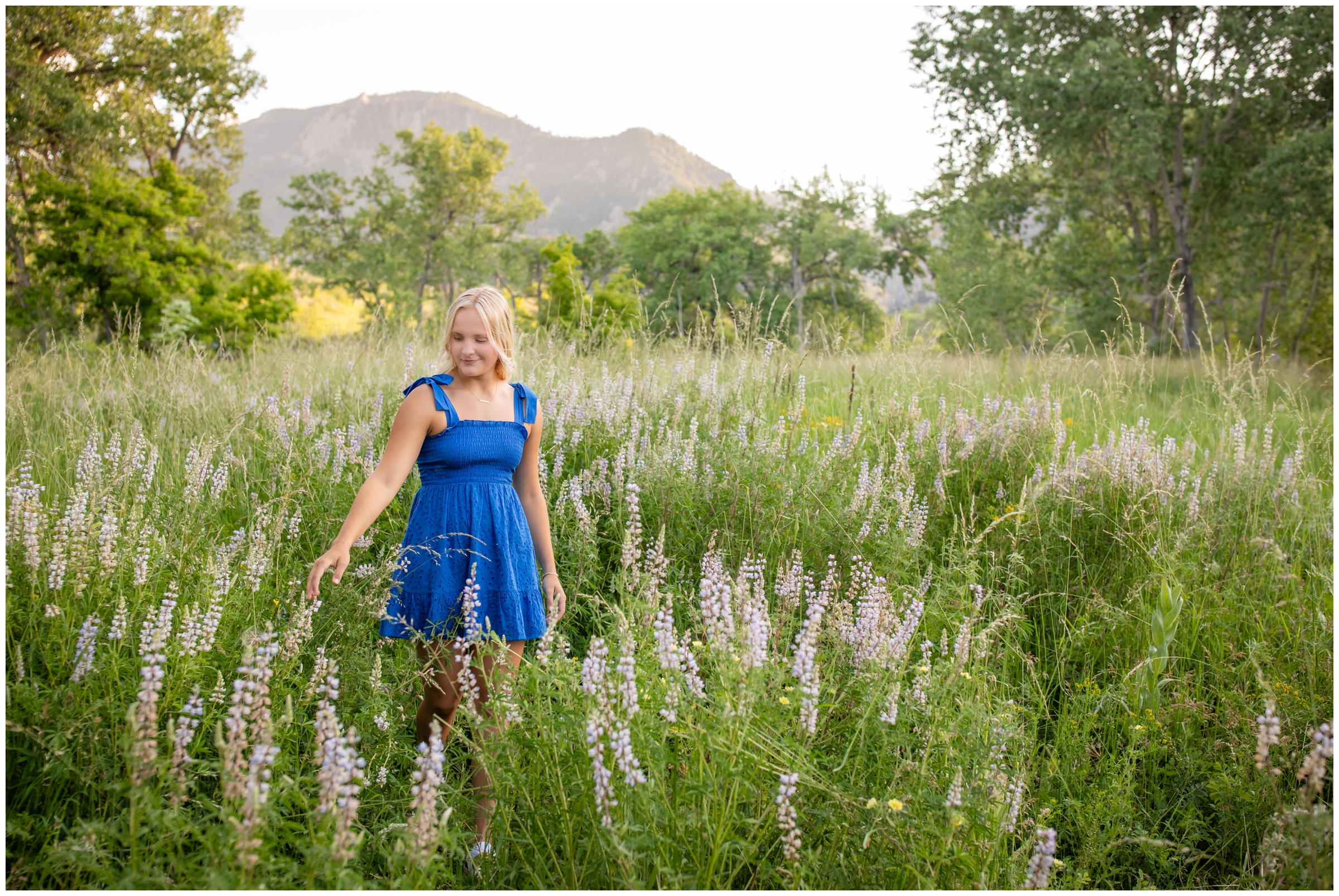 teen walking through a flower field during Boulder graduation senior pictures during summer