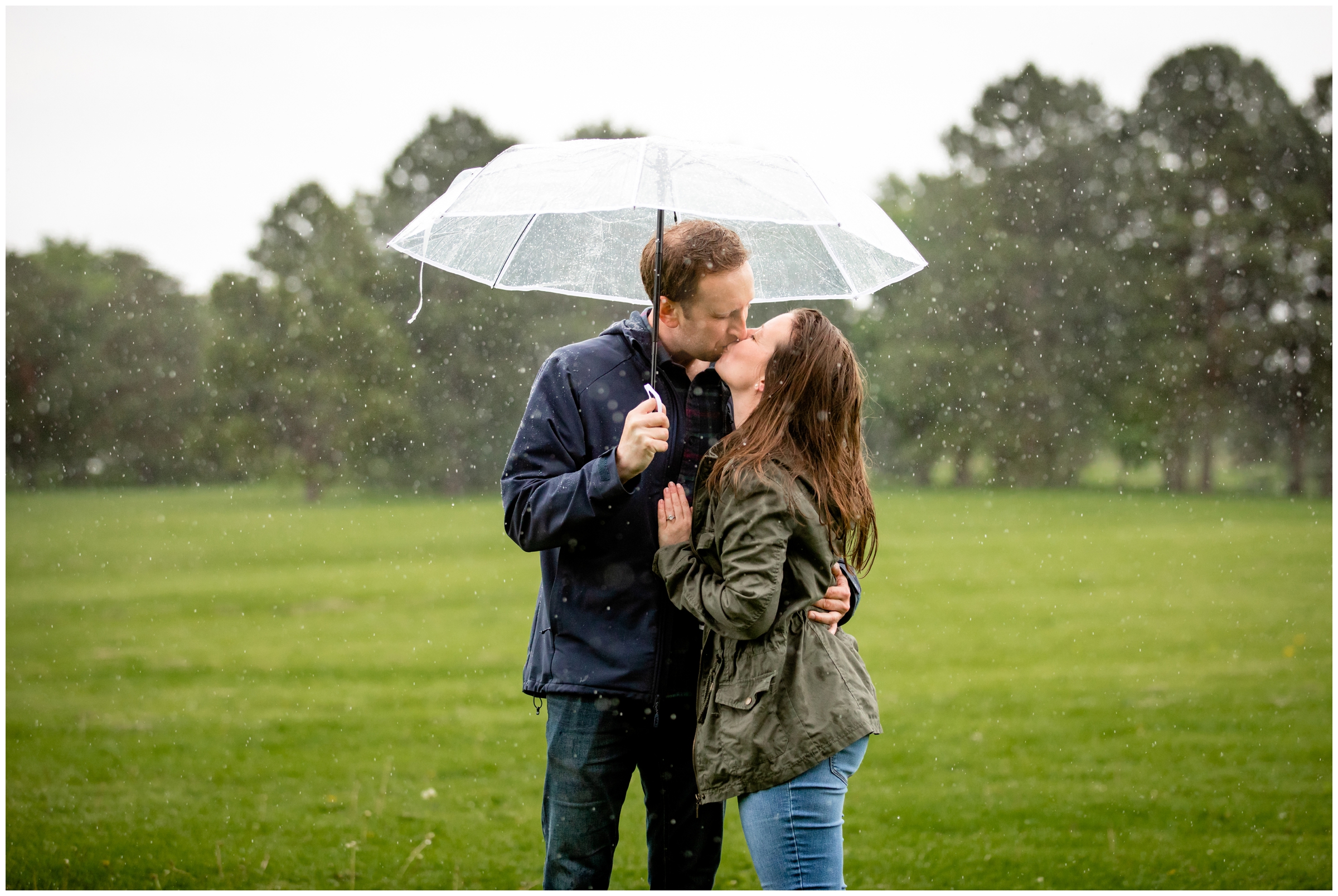 couple kissing under an umbrella during rainy proposal engagement photos in Denver Colorado