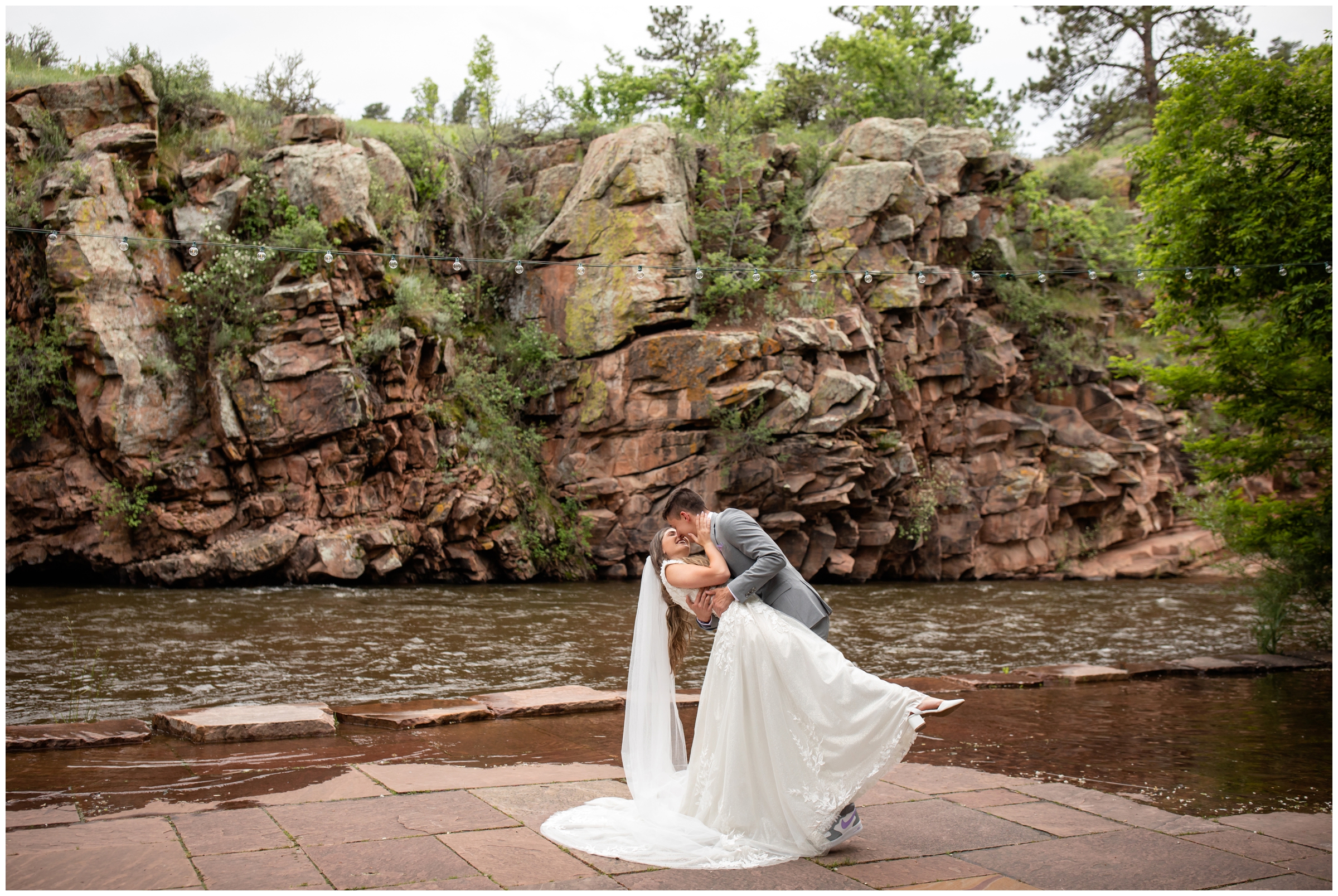 groom dipping bride next to the river during Lyons Colorado wedding pictures at River Bend 