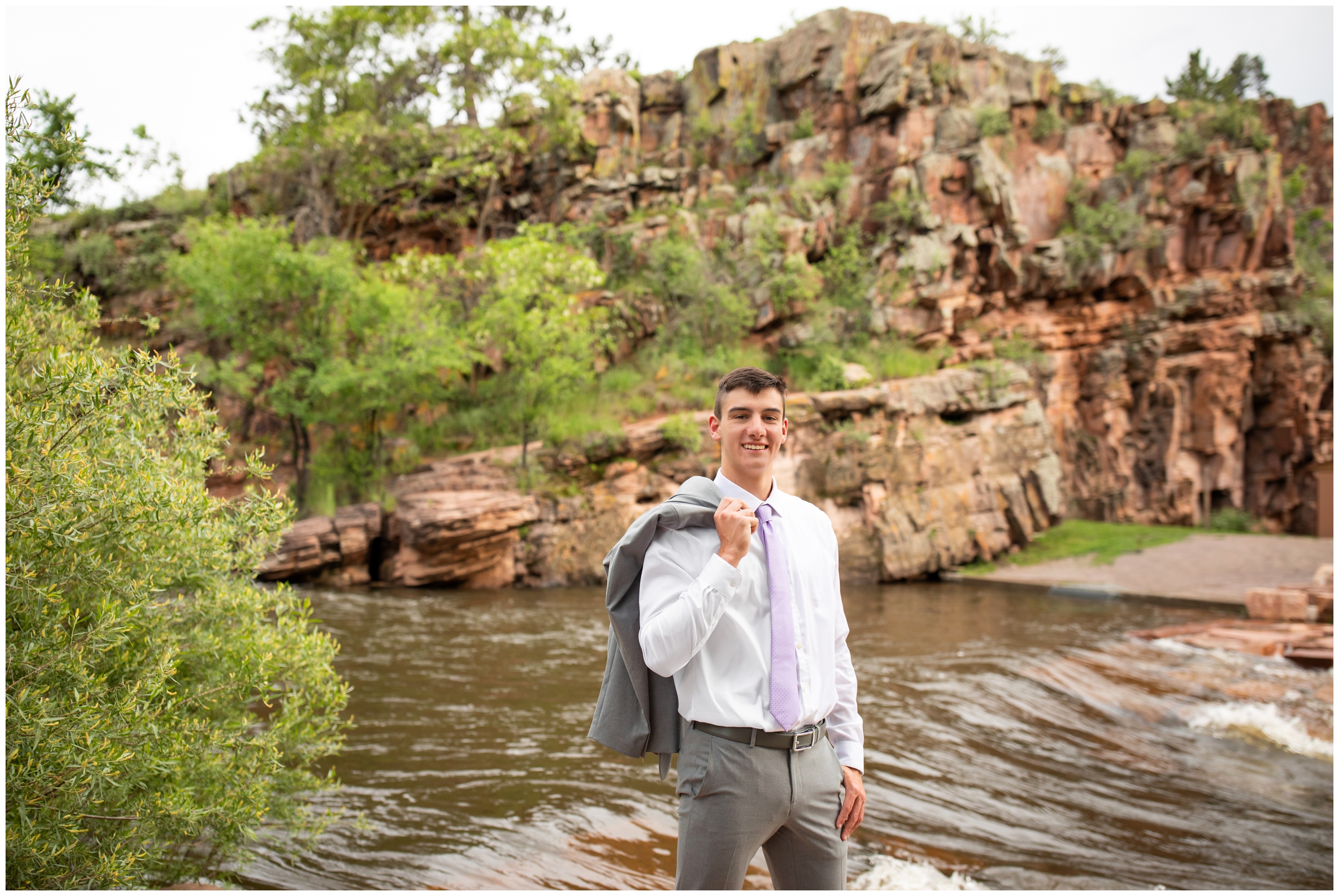 groom posing next to the river during Lyons Farmette River Bend summer wedding in Colorado 