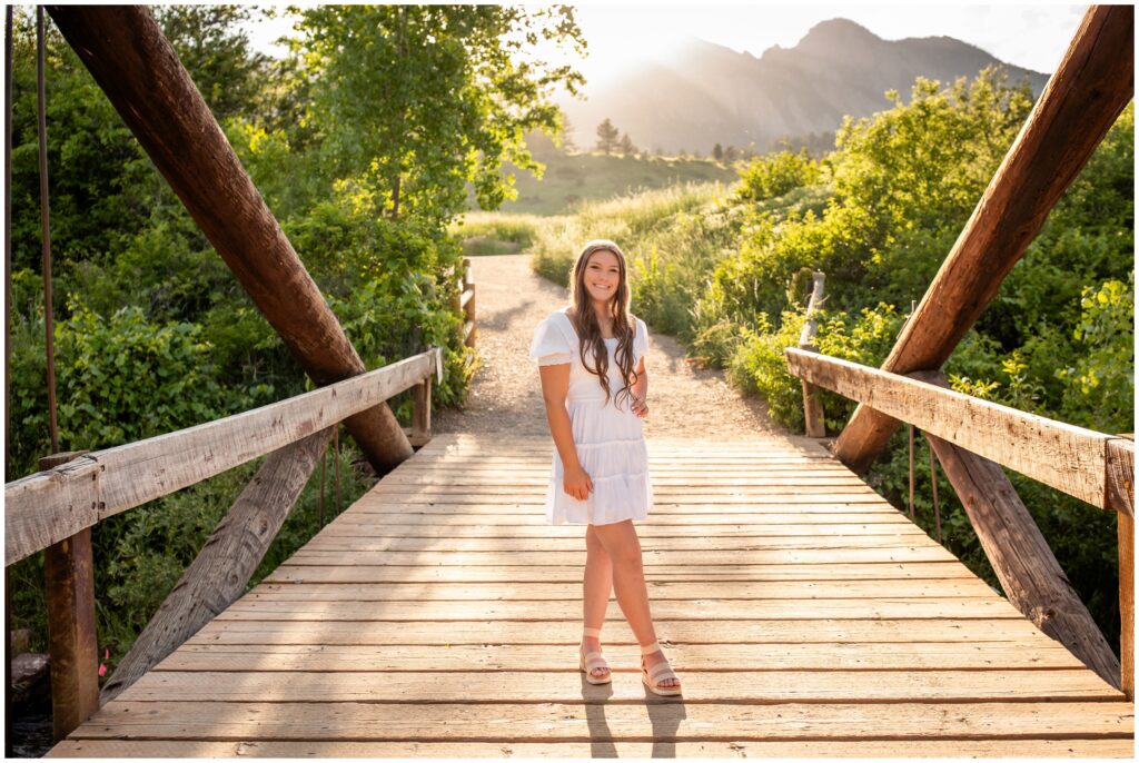 teen posing on wooden bridge during Boulder Colorado senior pictures by Plum Pretty Photos