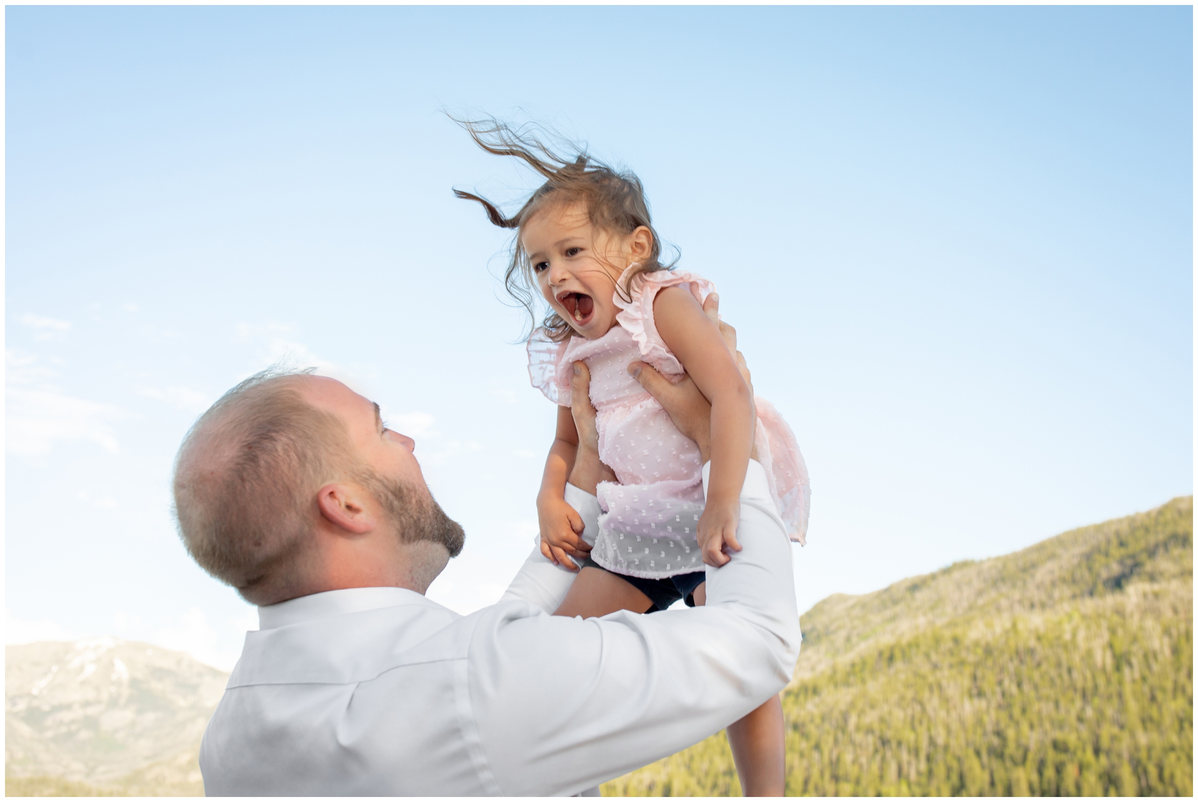 dad lifting daughter in the air during candid family photo session in Grand Lake Colorado 