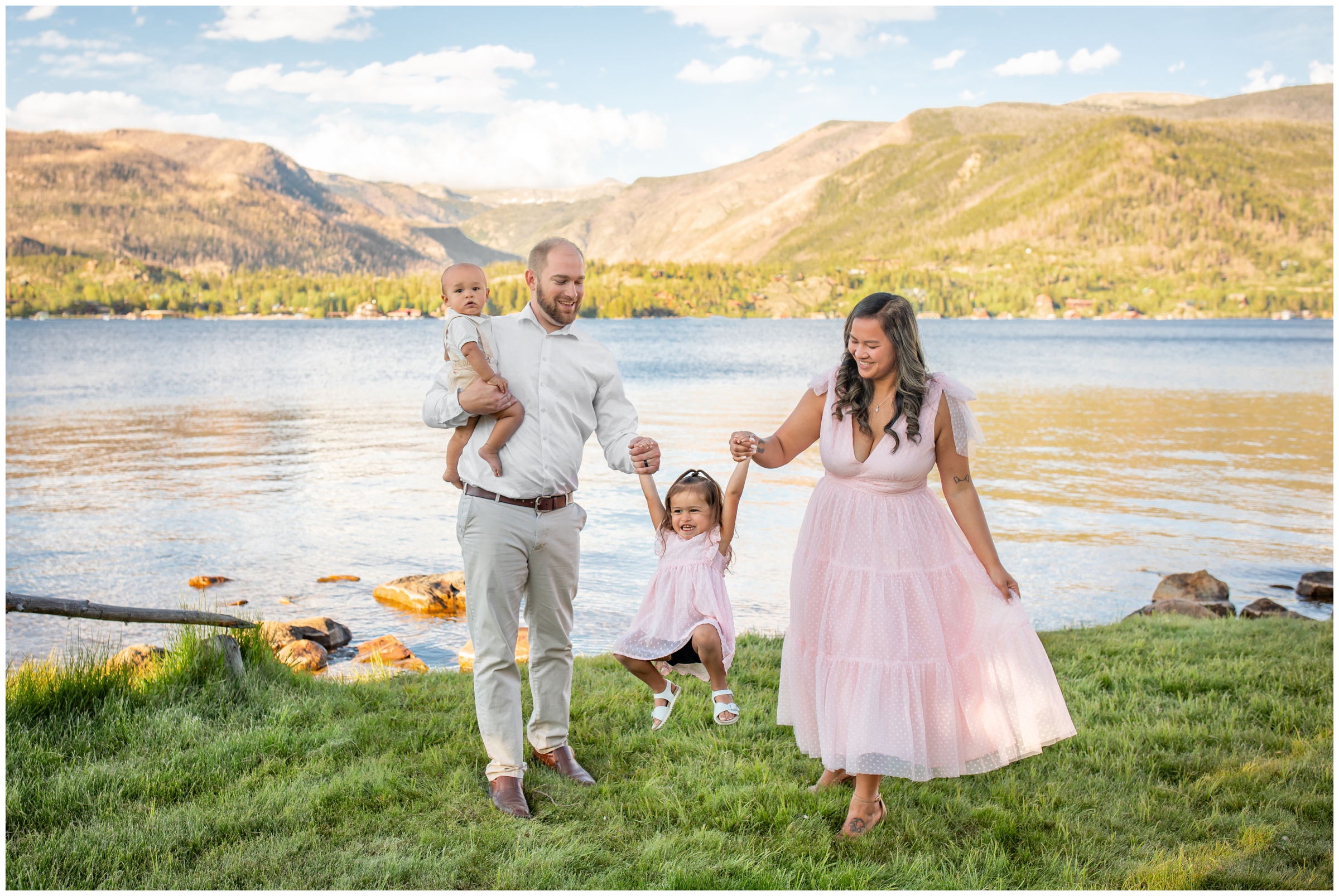 parents swinging daughter during candid family photos in Colorado mountains at Grand Lake
