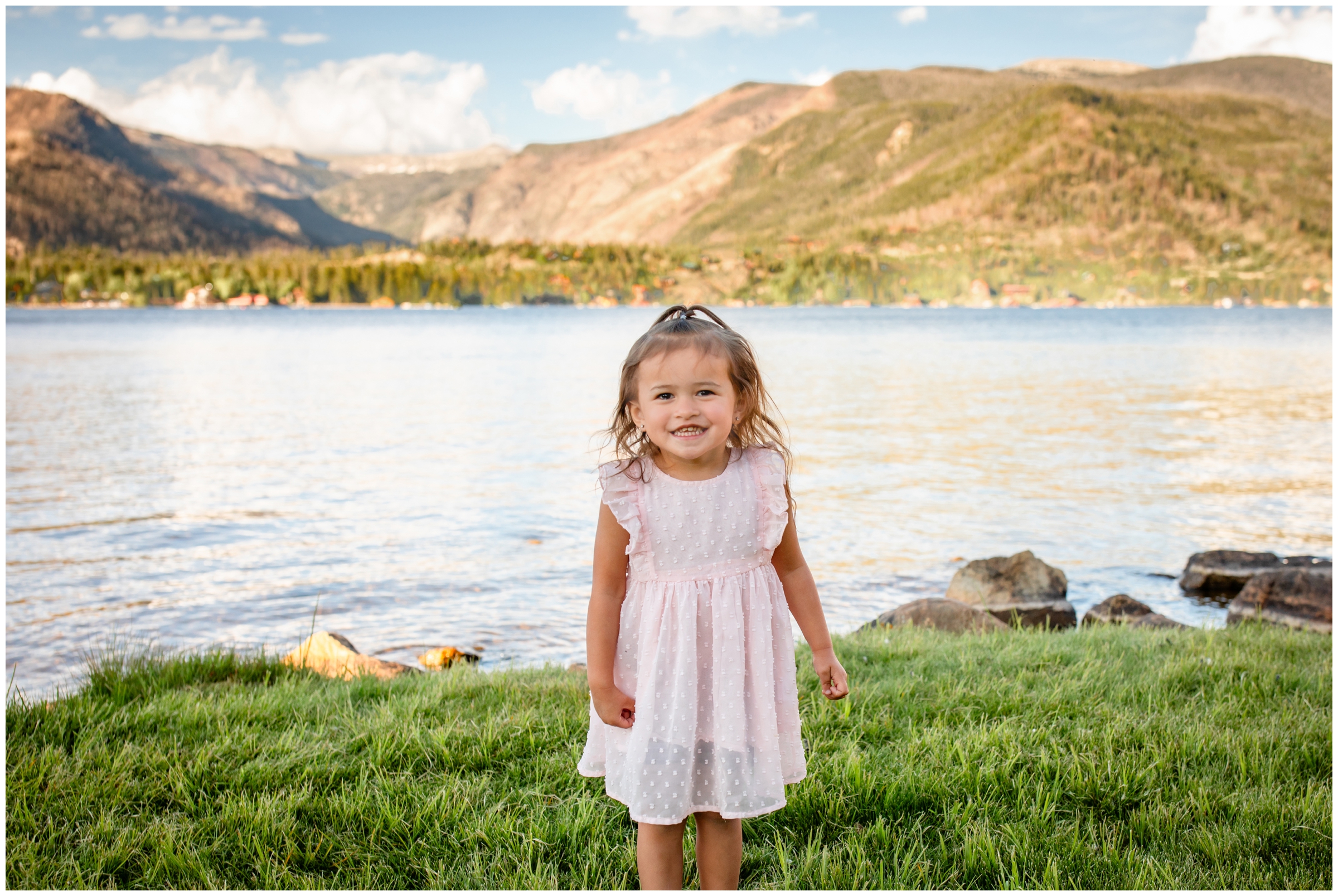 little girl posing in front of mountain lake during Grand Lake Colorado family photography session at Point Park