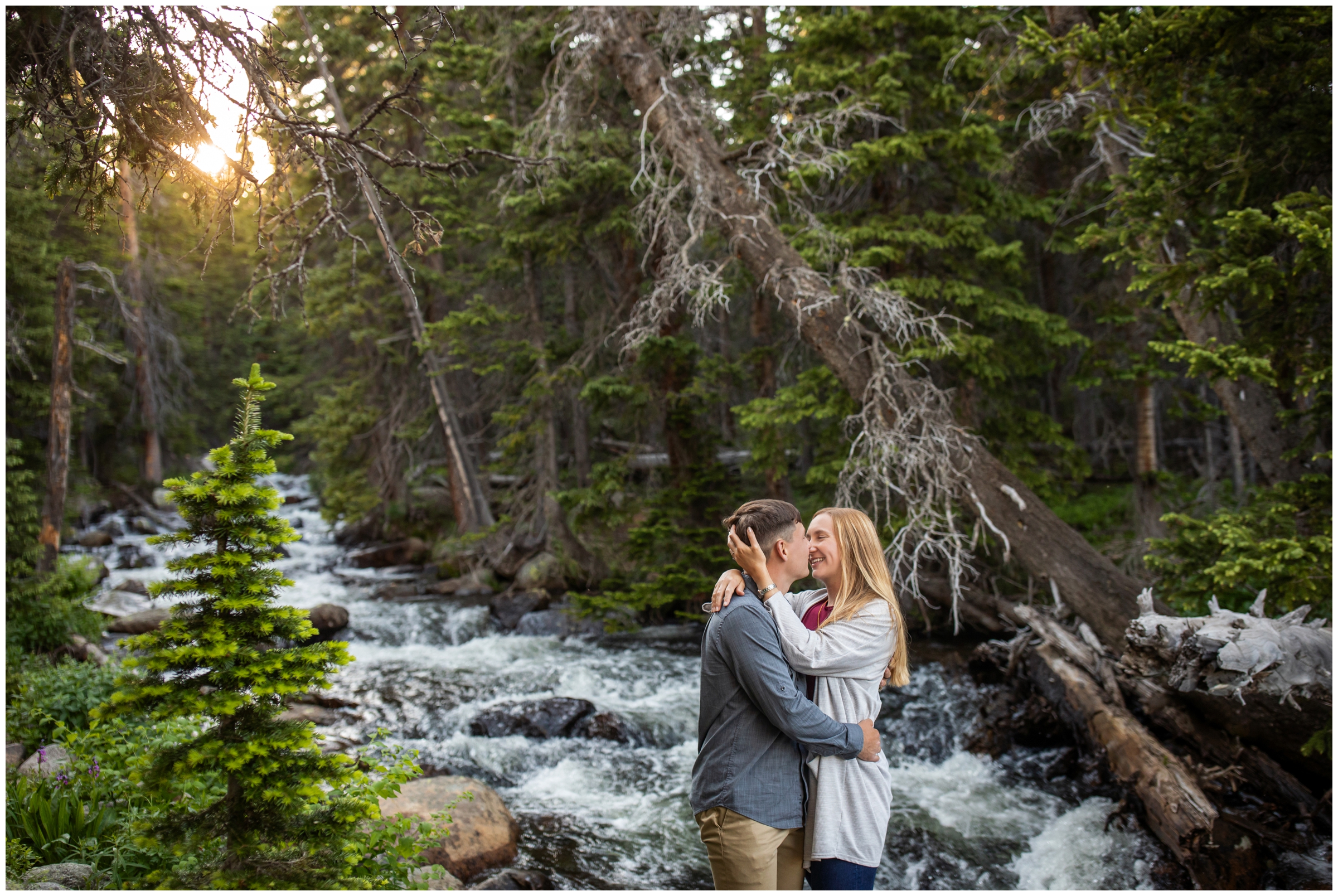 couple cuddling during forest engagement pictures in Colorado mountains 
