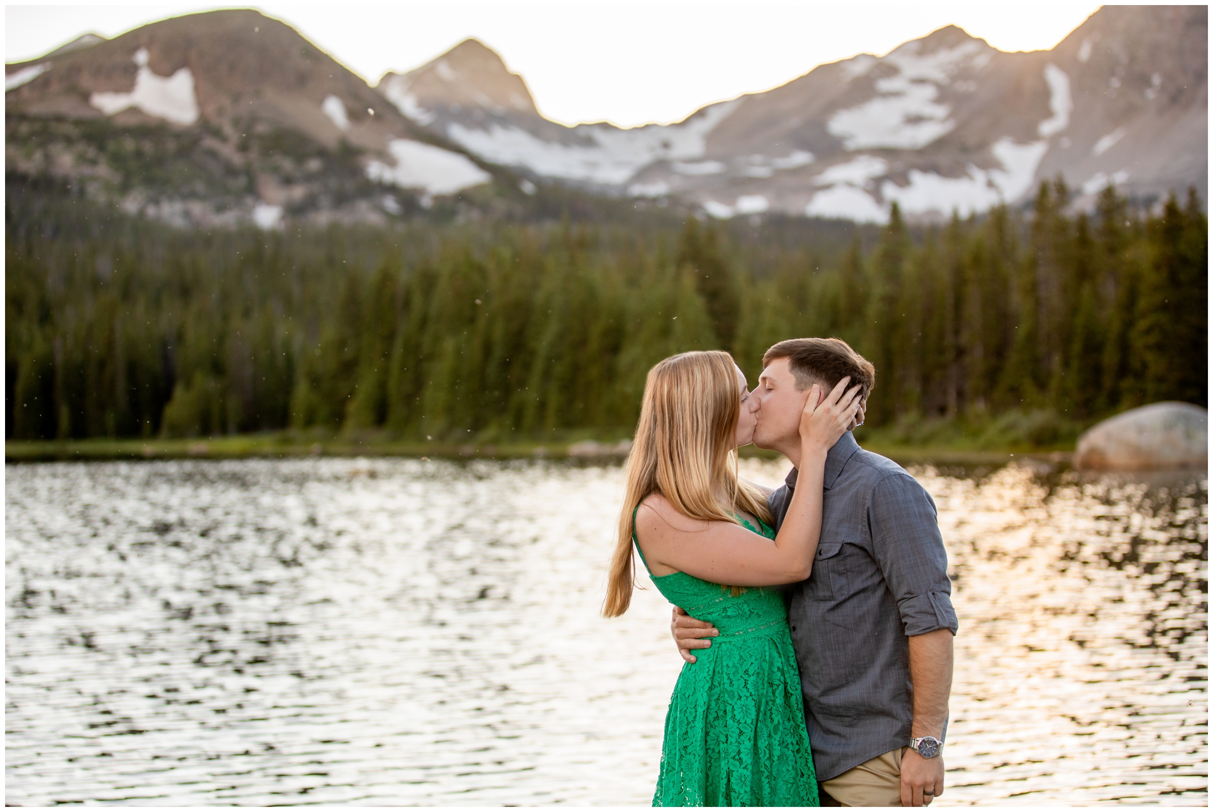 couple kissing in front of mountain lake during Colorado engagement photography session at Brainard Lake