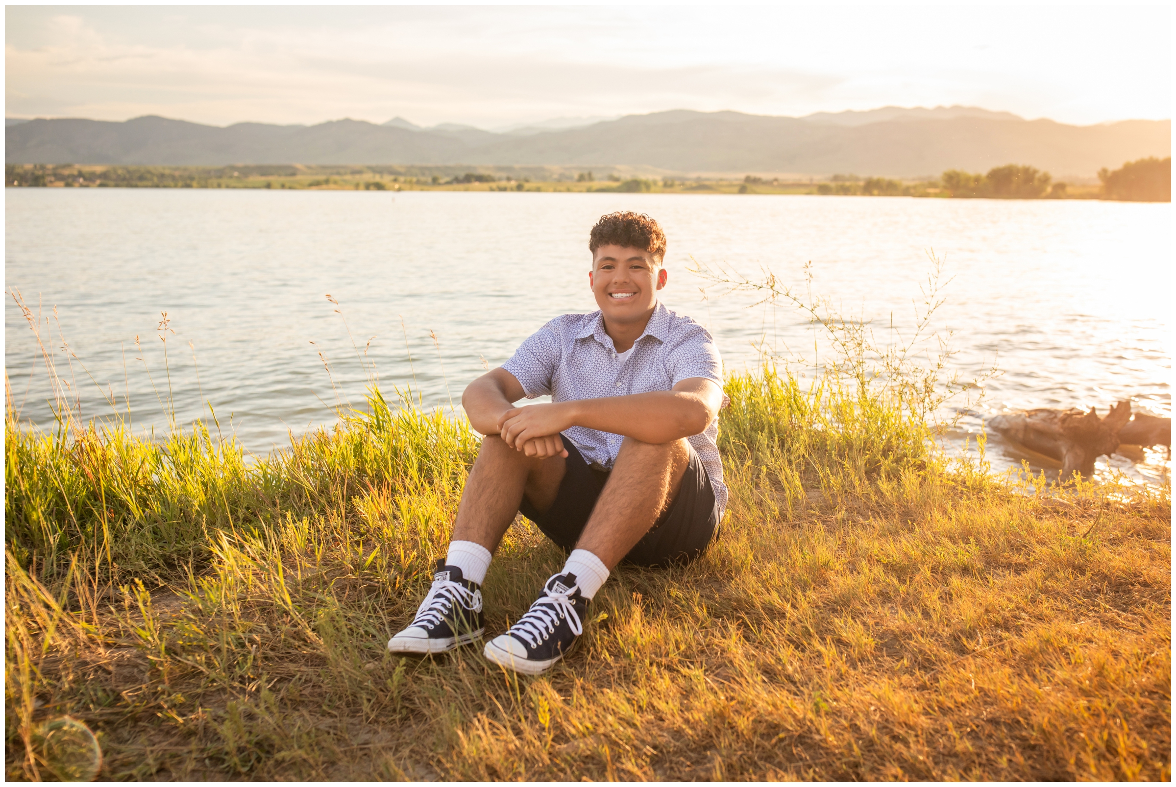 teen guy sitting in front of Boulder reservoir during Colorado senior pictures by Plum Pretty Photography