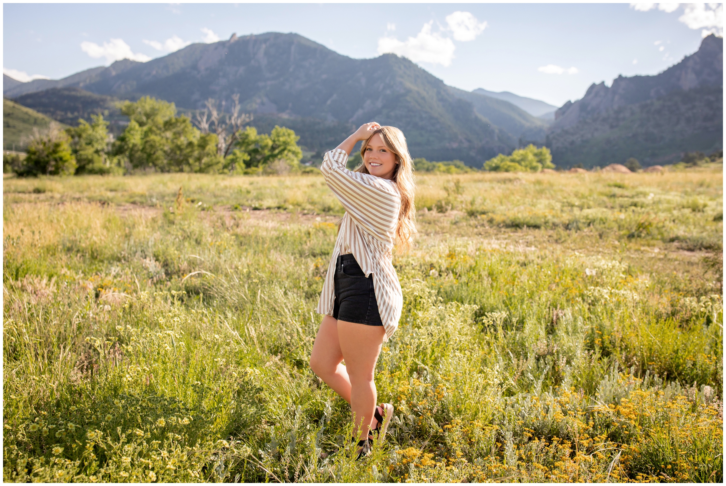 teen posing in a field with mountains in background during Boulder Colorado senior photography session at South mesa trail 