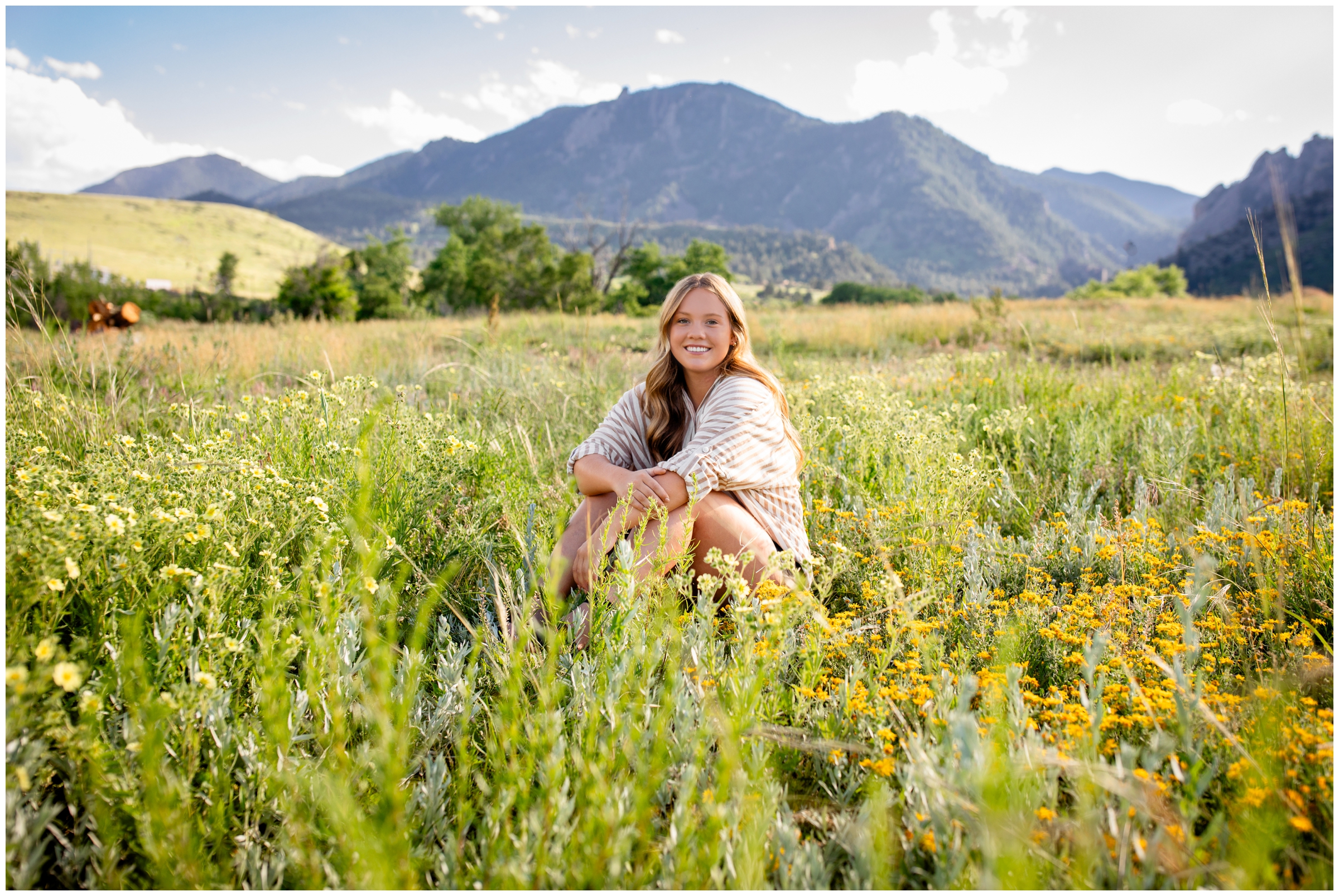 teen sitting in mountain field during summer senior pictures in Boulder Colorado 