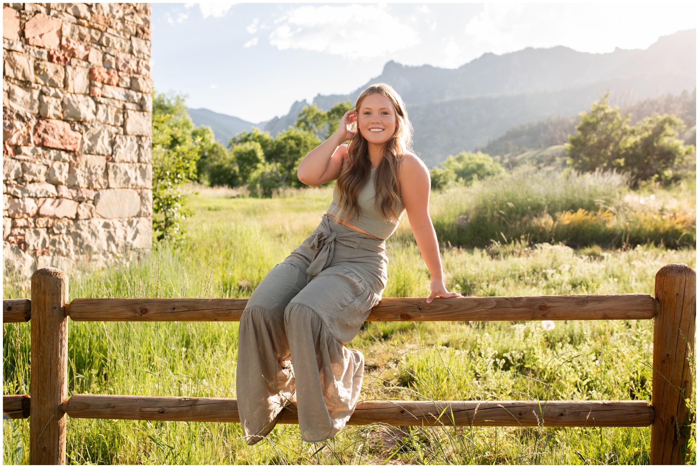 teen sitting on fence during Boulder graduation photography session at South Mesa trail 
