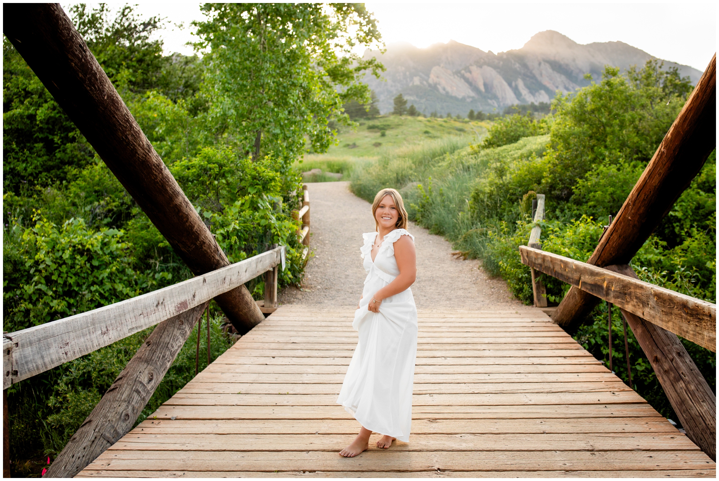 teen twirling on bridge with mountains in background during Boulder colorado high school senior photography session 