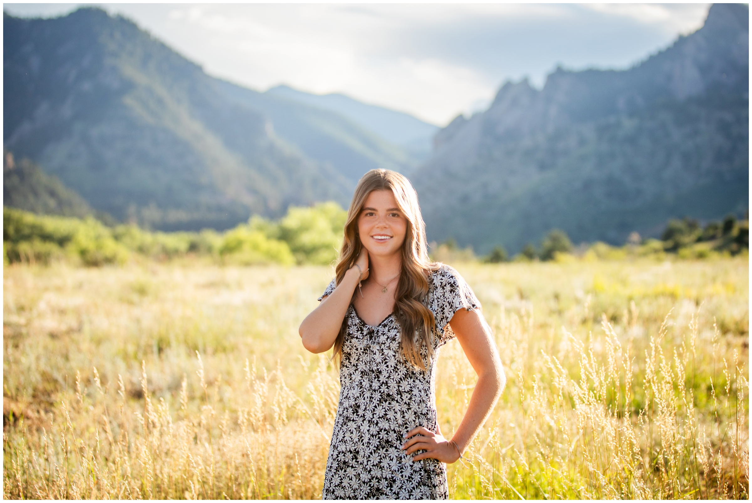 teen posing in a field with mountains in background during Boulder Colorado senior photos