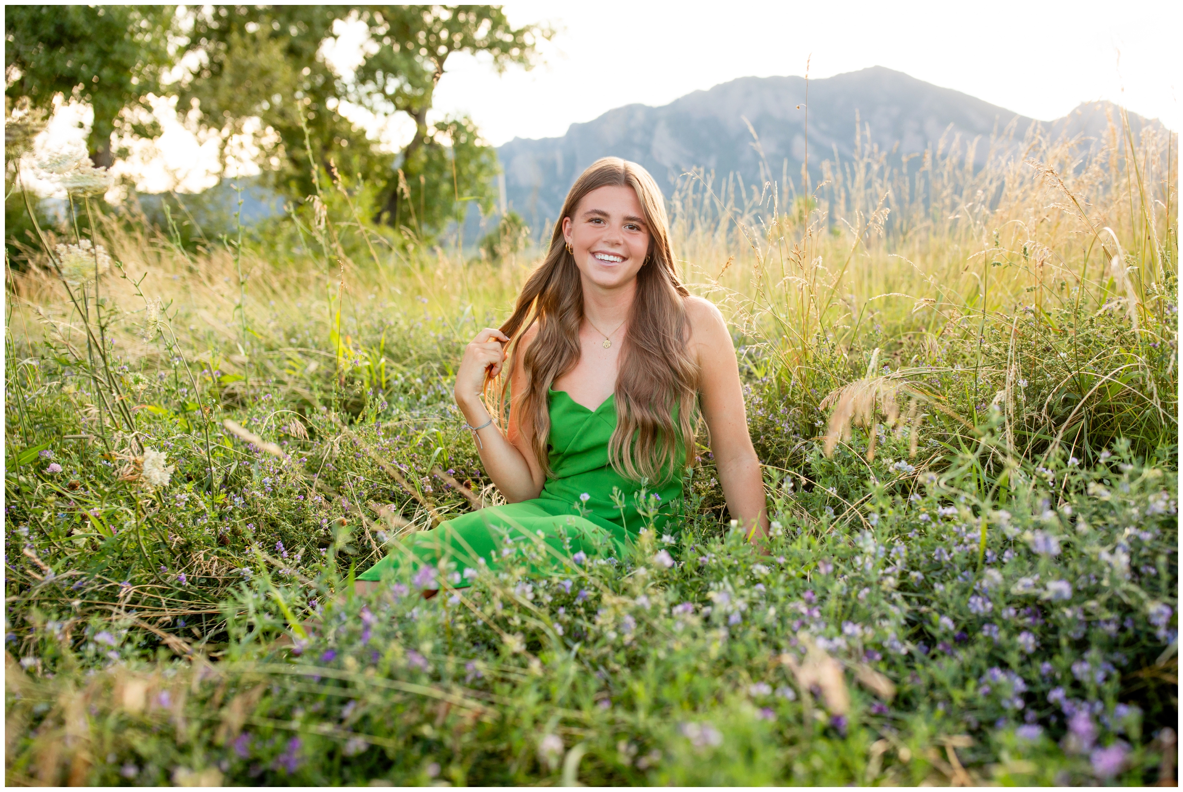 teen sitting in wildflowers during Boulder senior portraits