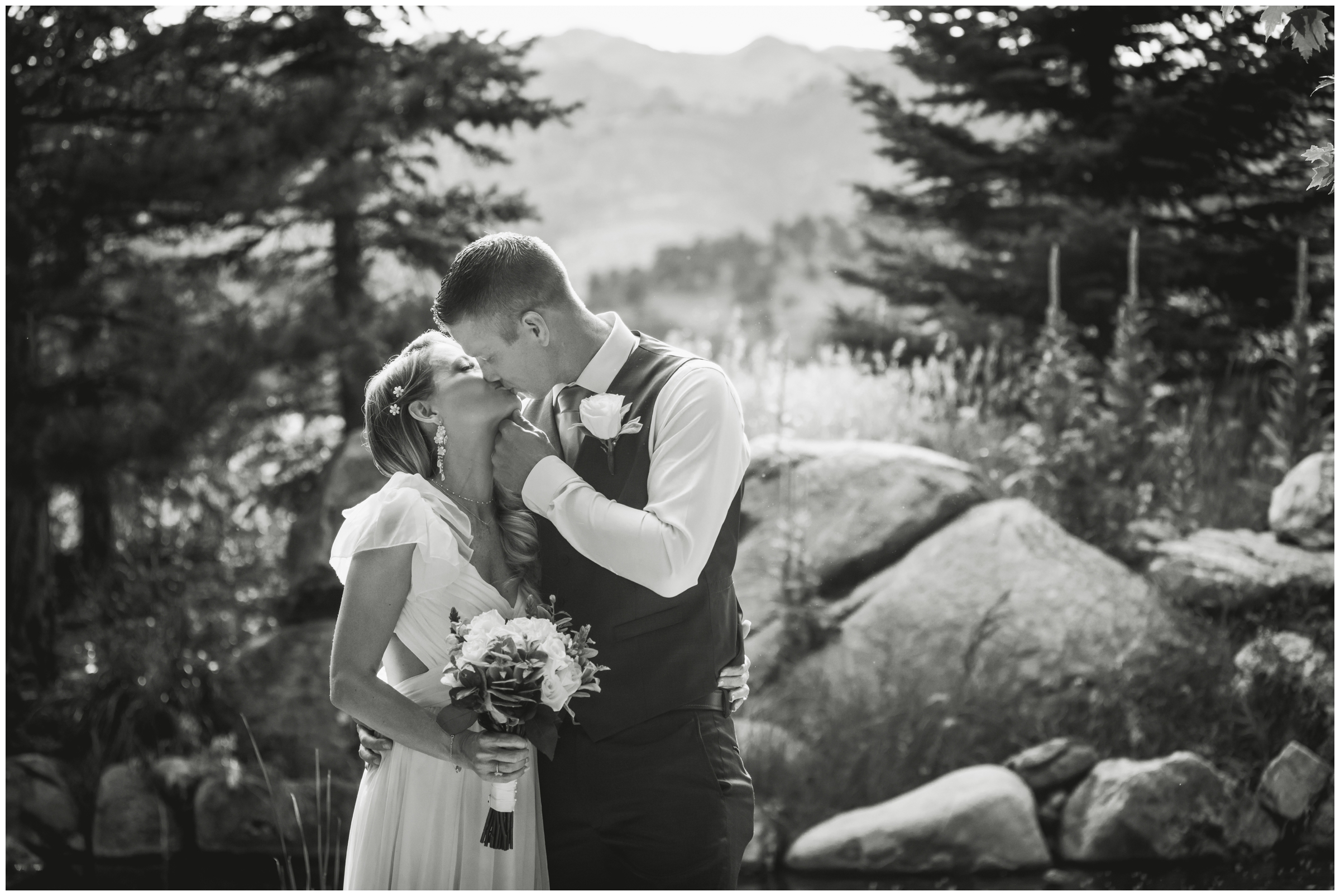 couple kissing with mountains in background during Boulder wedding photos at Greenbriar Inn