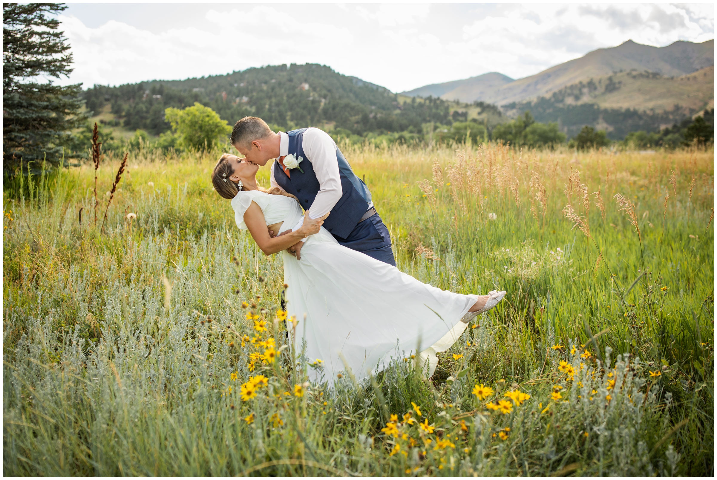 couple kissing in field of wildflowers during Boulder Colorado summer wedding photos at the Greenbriar Inn