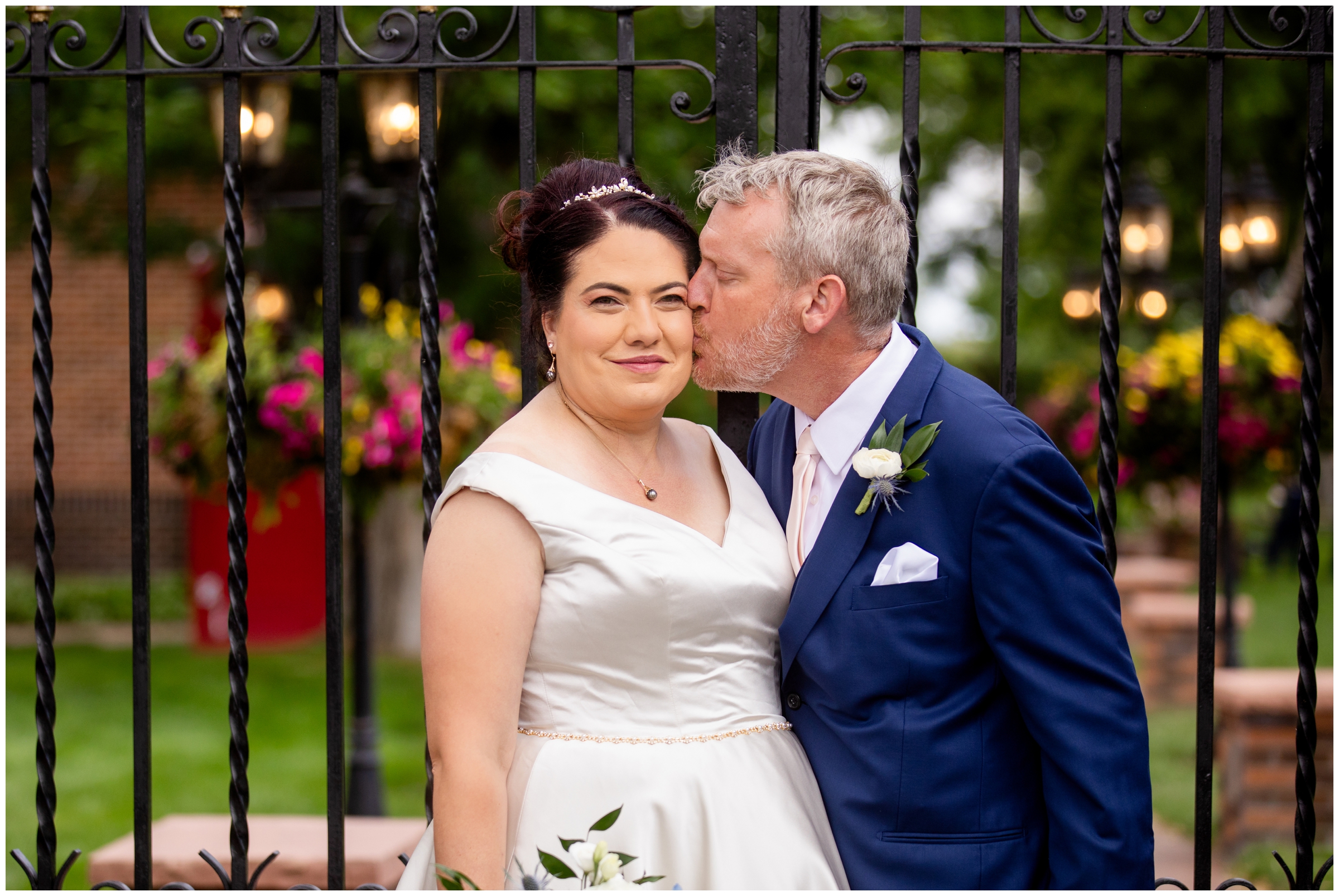 couple posing in front of wrought iron gates during Colorado Dove House wedding photography 