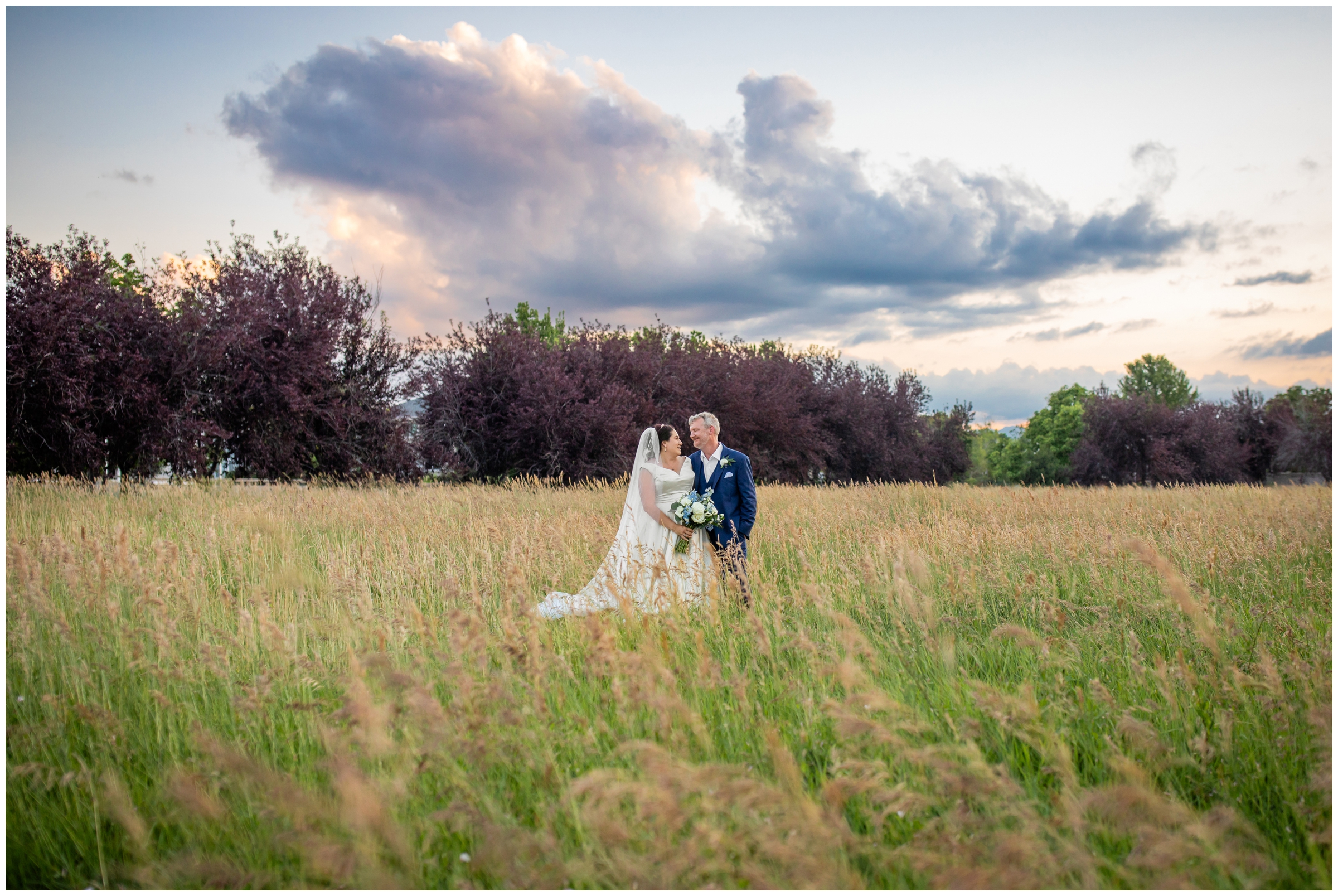 couple posing in field at sunset during Lionsgate event center Colorado wedding pictures 