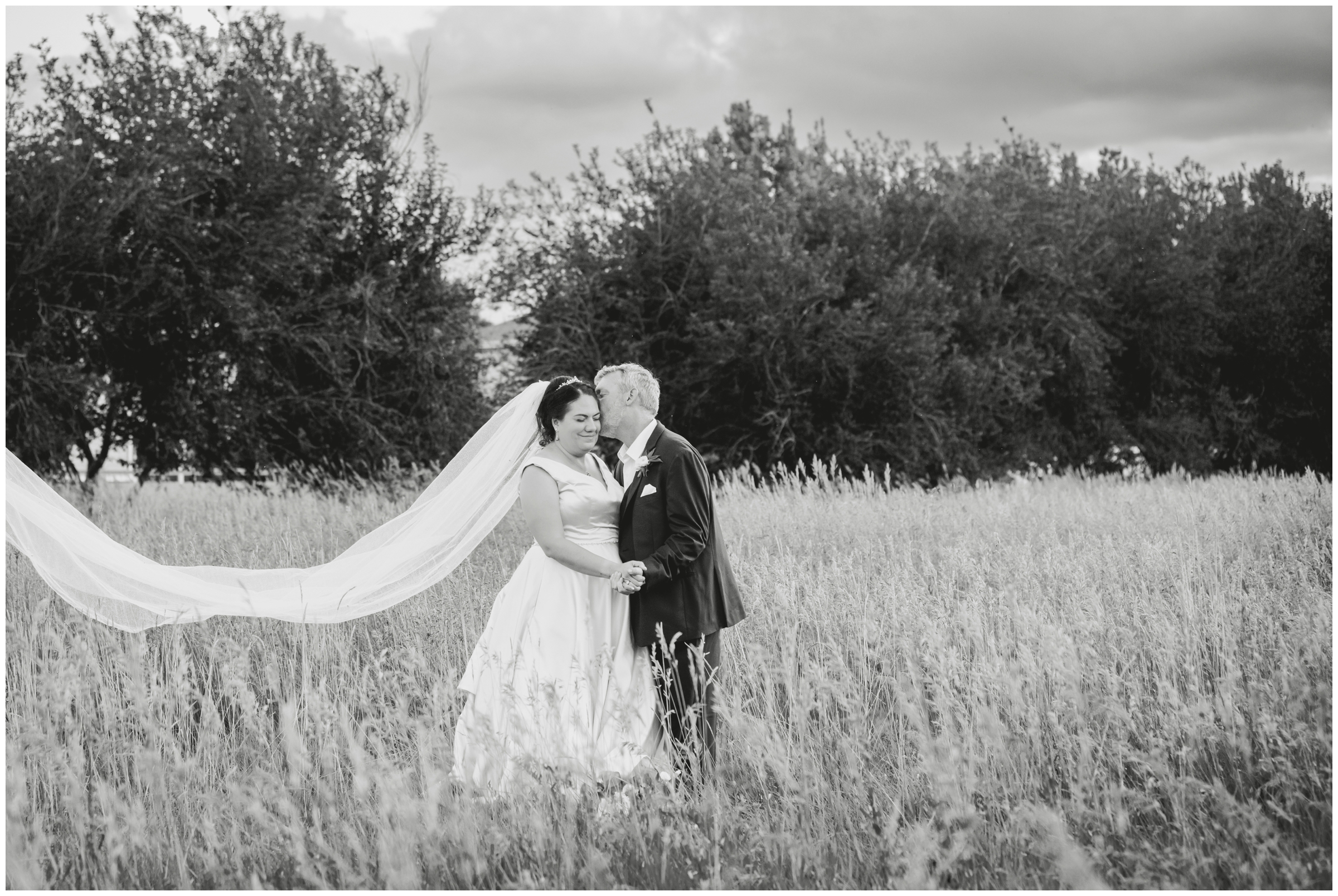 couple posing in a field after Chandelier Barn Colorado summer wedding portraits 