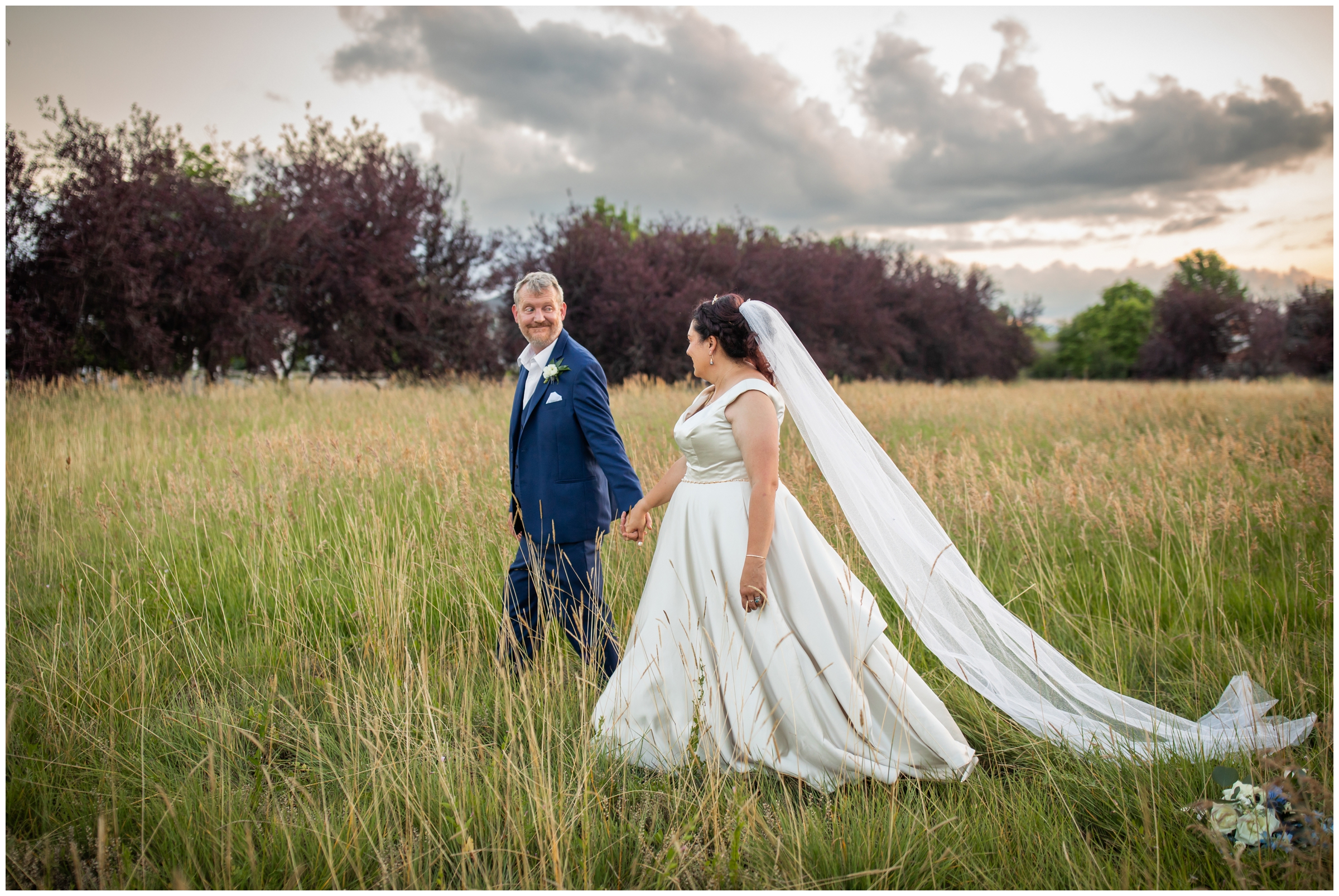 couple walking through a field at sunset during Colorado summer wedding portraits at Lionsgate Event Center 