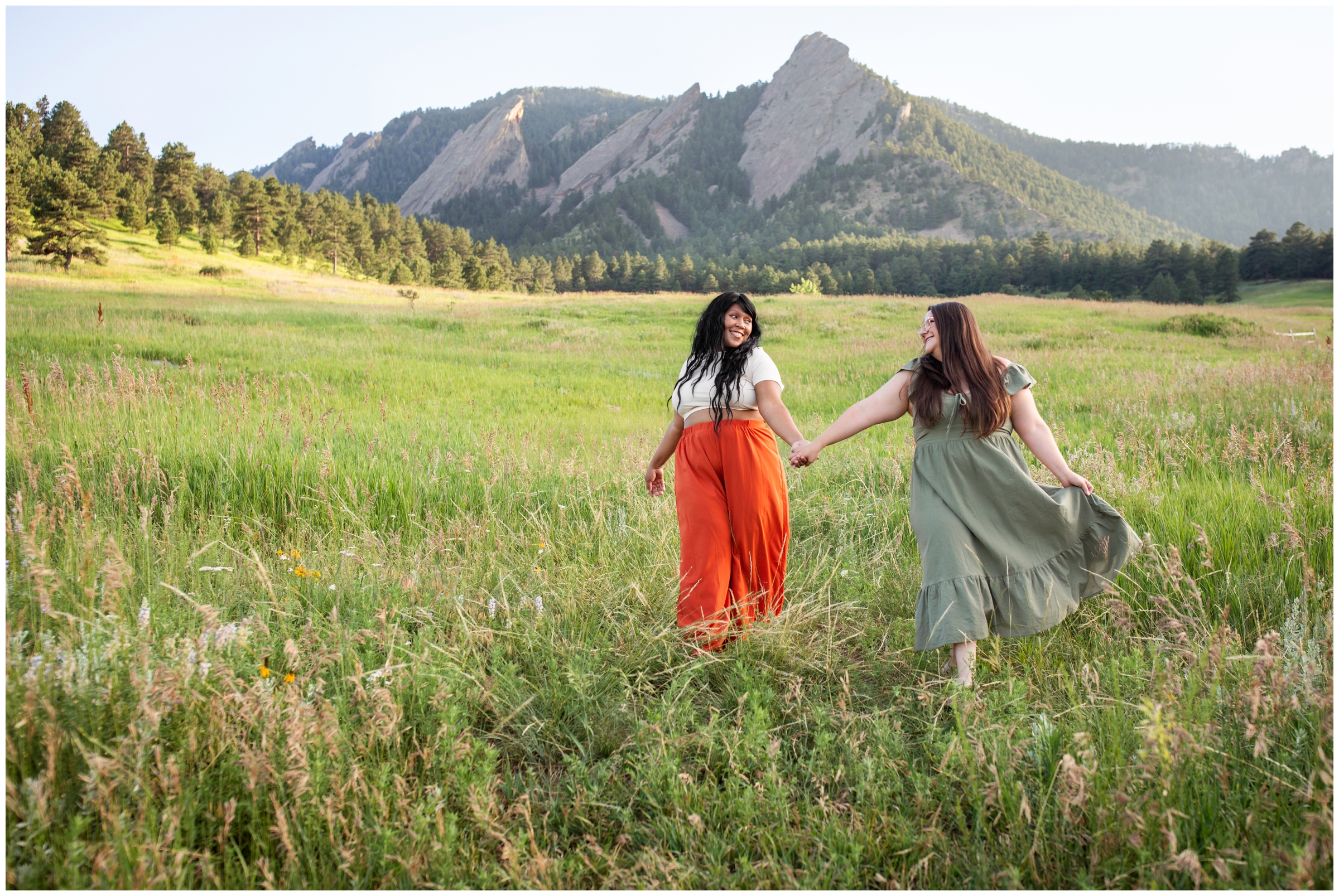 best friends walking through a field during Boulder Colorado summer photography session at Chautauqua Park 