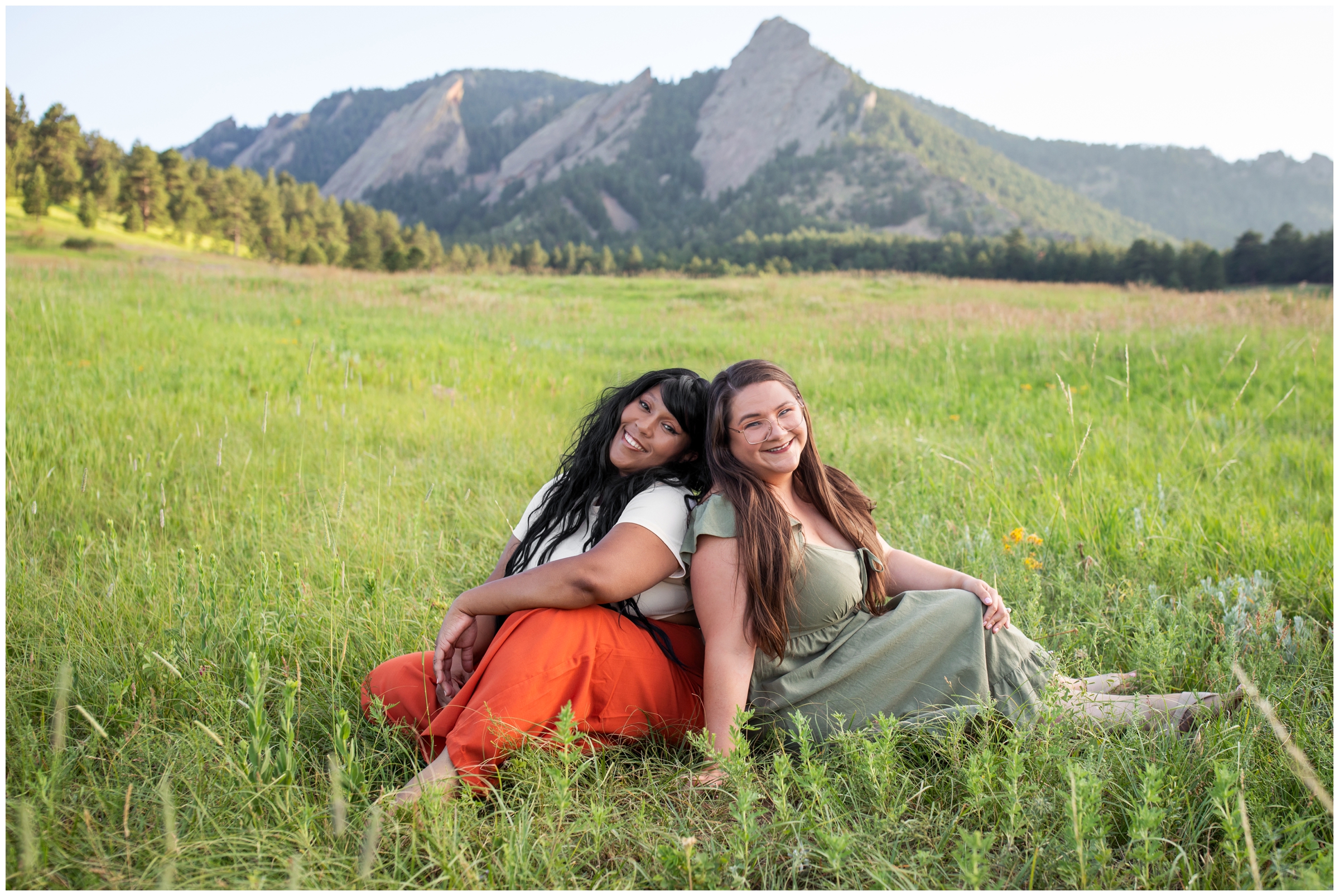two women sitting in a field at Chautauqua during Boulder Colorado best friends photo shoot