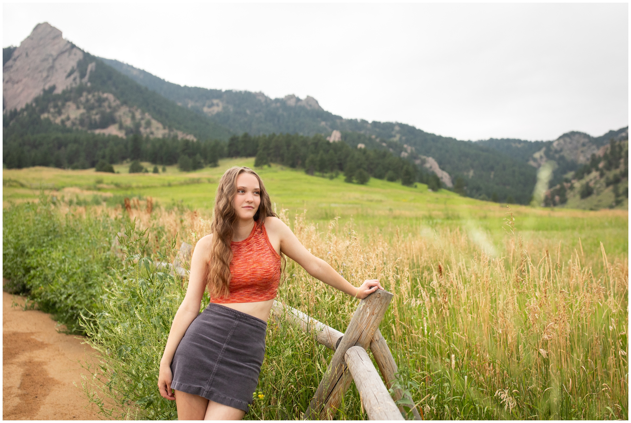 teen leaning on wooden fence during Boulder Colorado senior portraits at Chautauqua flatirons