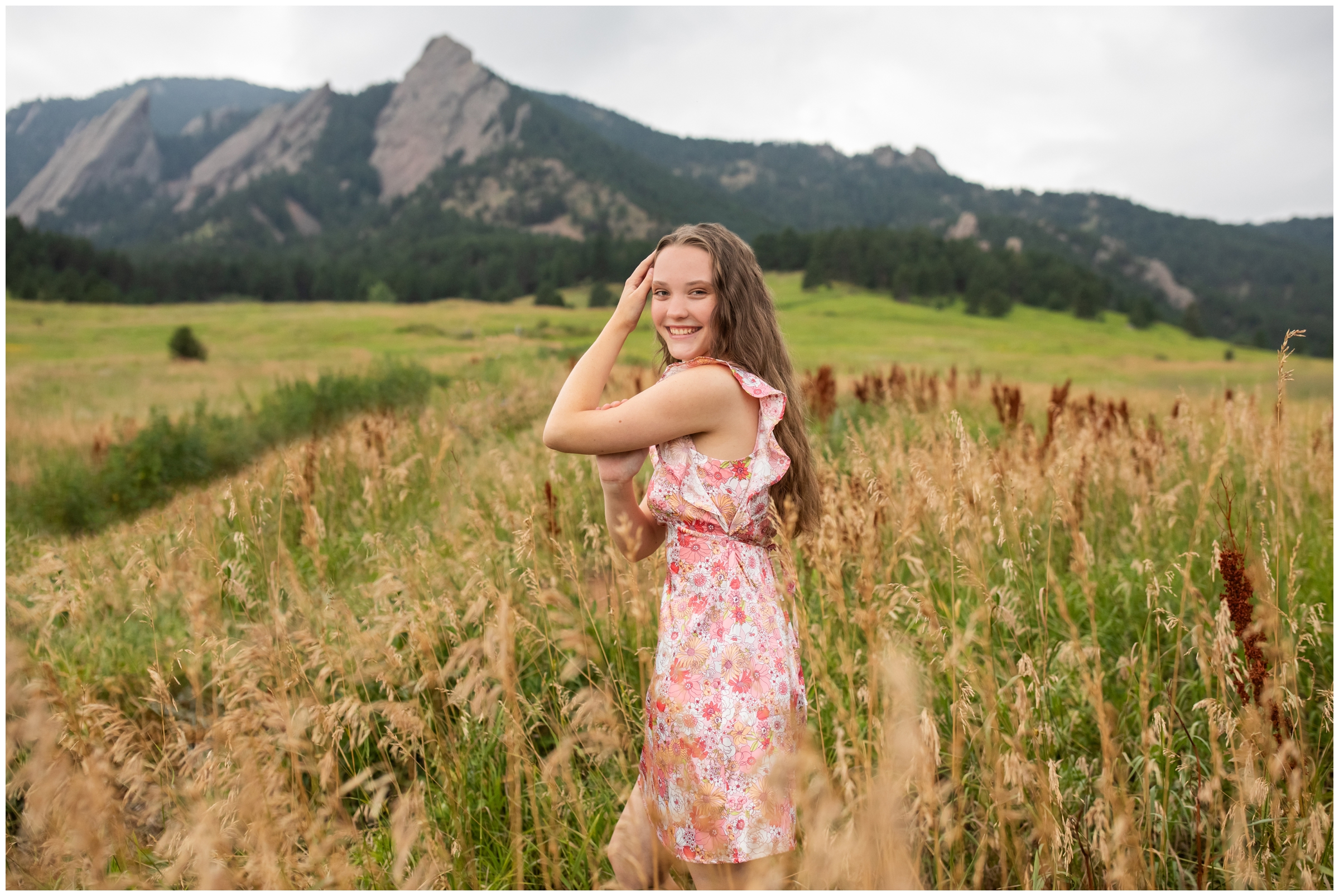 teen posing in field of long grasses during flatirons mountains photography session at Chautauqua in boulder Colorado 