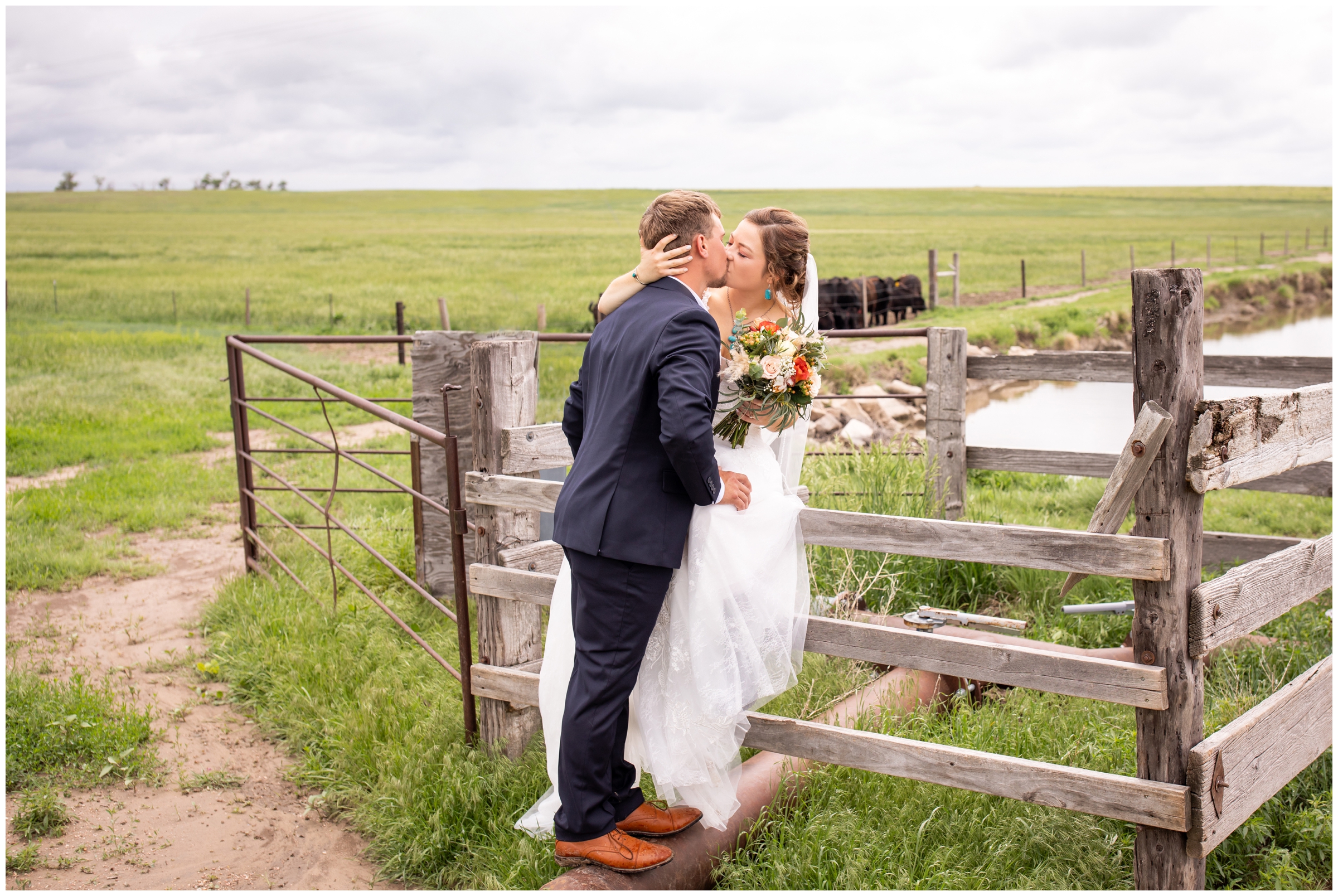 couple sitting on wooden fence during farm wedding photos in Crook Colorado