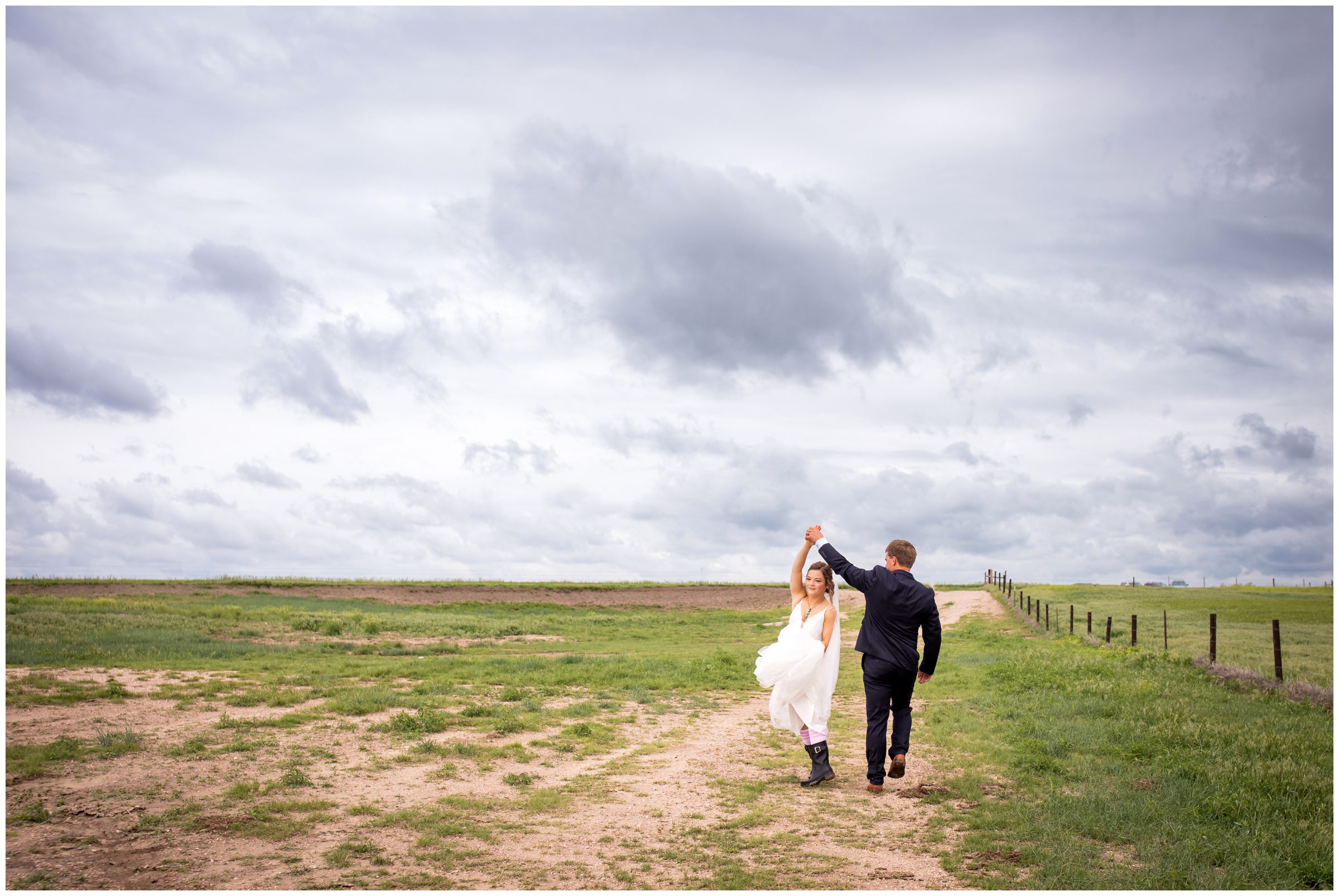 couple walking down dirt road during rustic farm wedding photos in Crook Colorado 