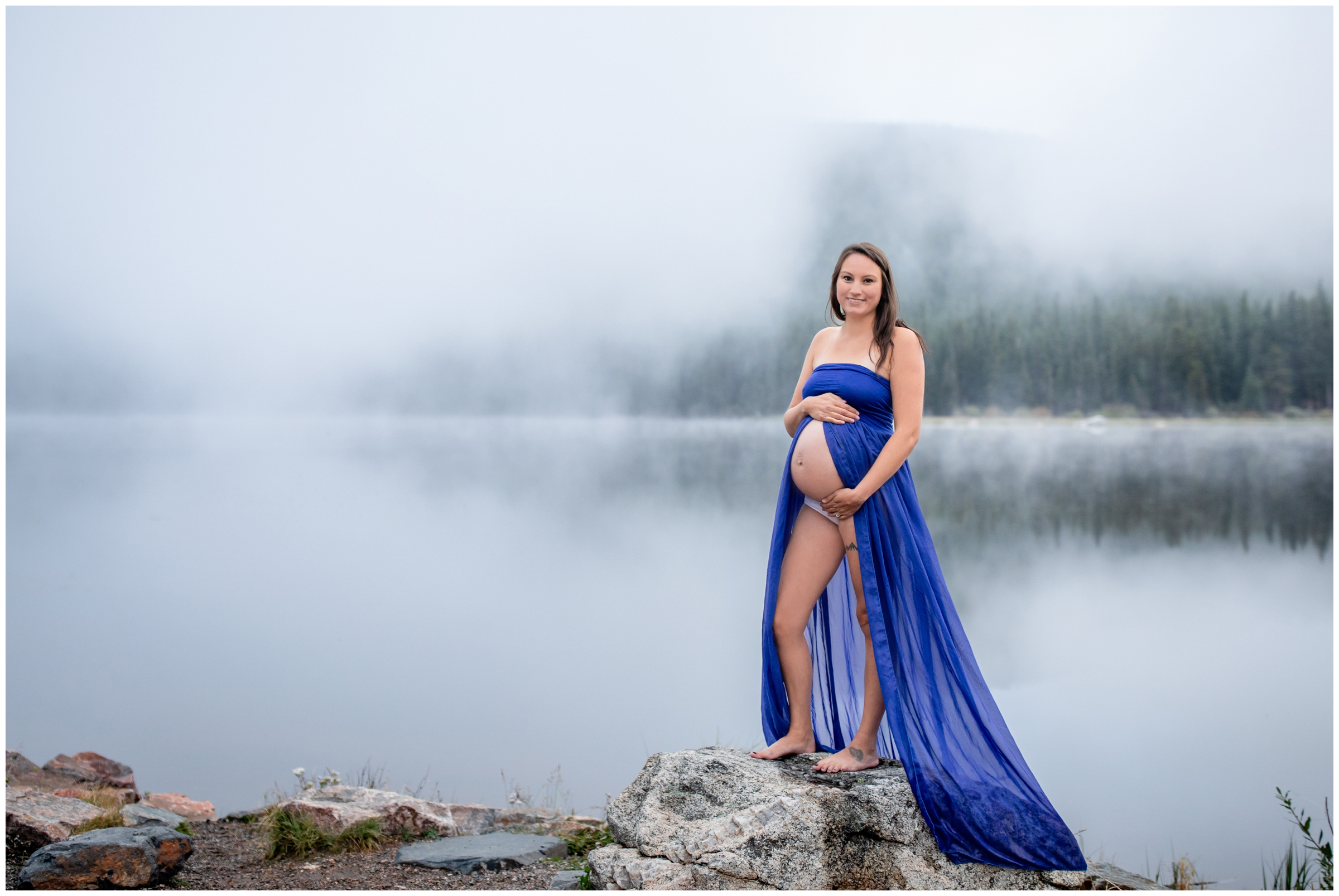 pregnant woman posing on a rock during foggy maternity photography session in Colorado 