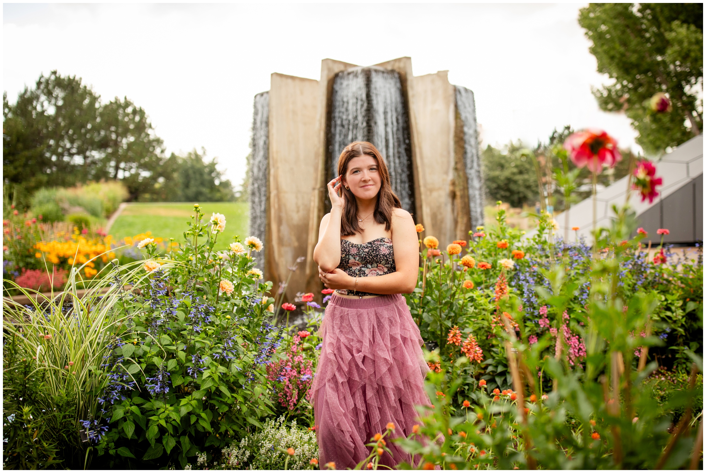 teen posing by water feature at Denver Botanic Gardens senior pictures during summer 