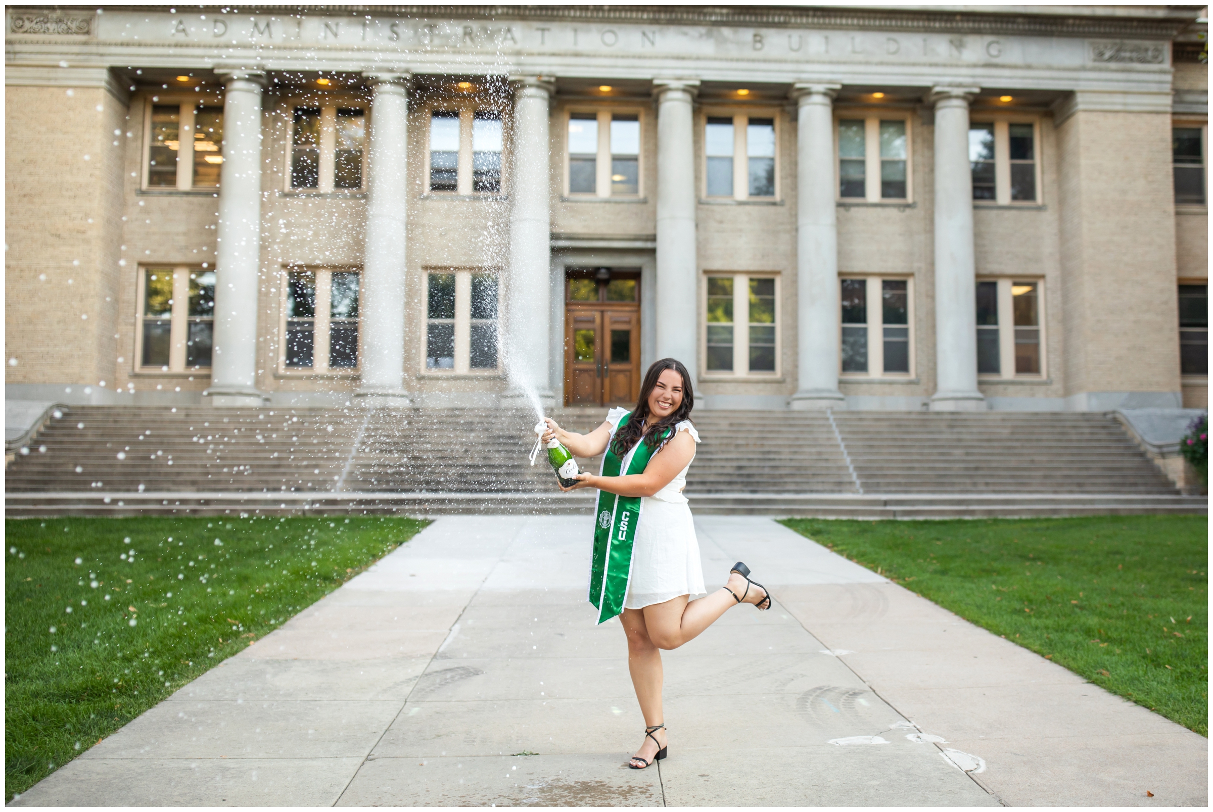 woman spraying champagne during college senior pictures at the CSU oval