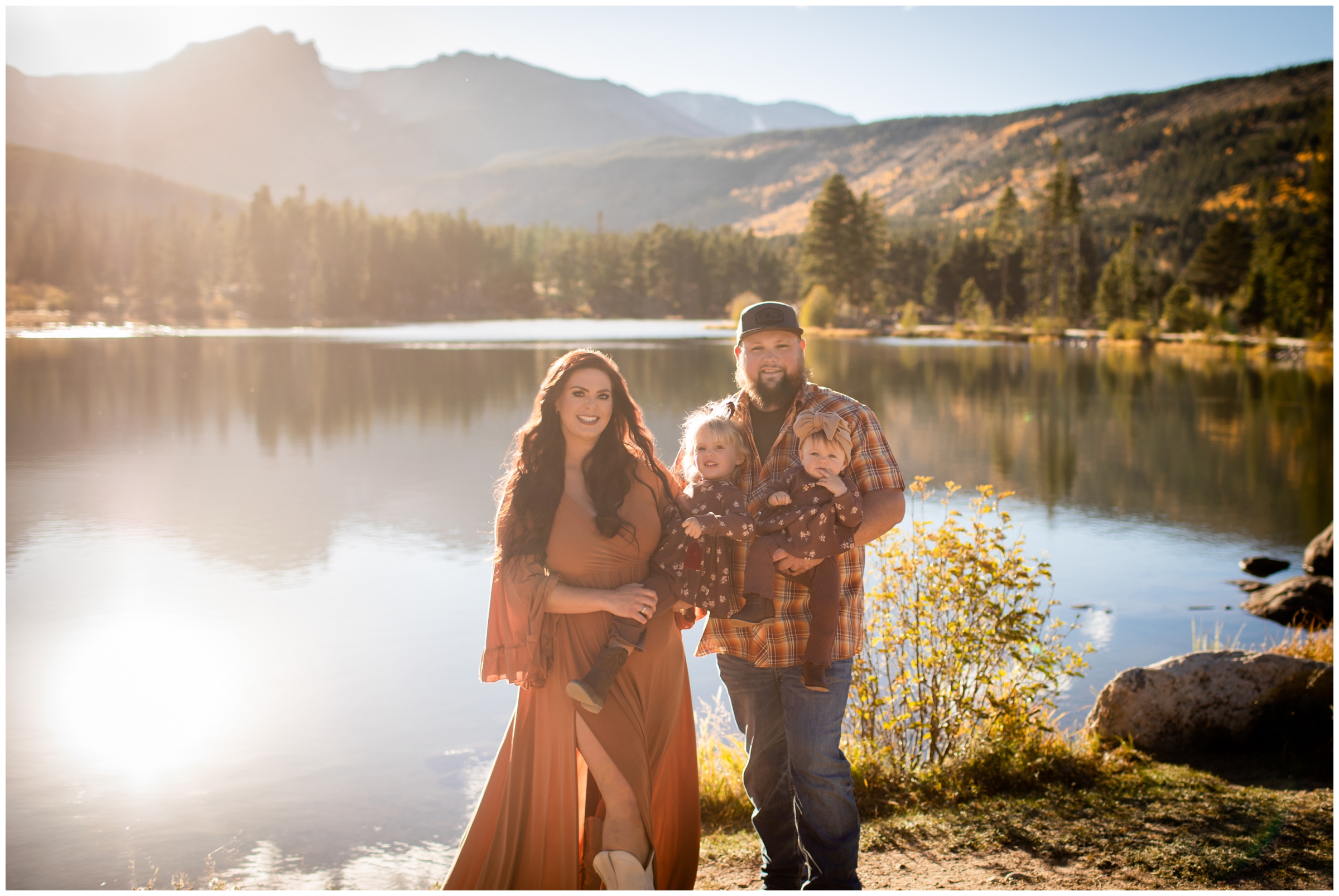 family posing in front of Sprague Lake during fall Colorado RMNP family portraits by Plum Pretty Photography 