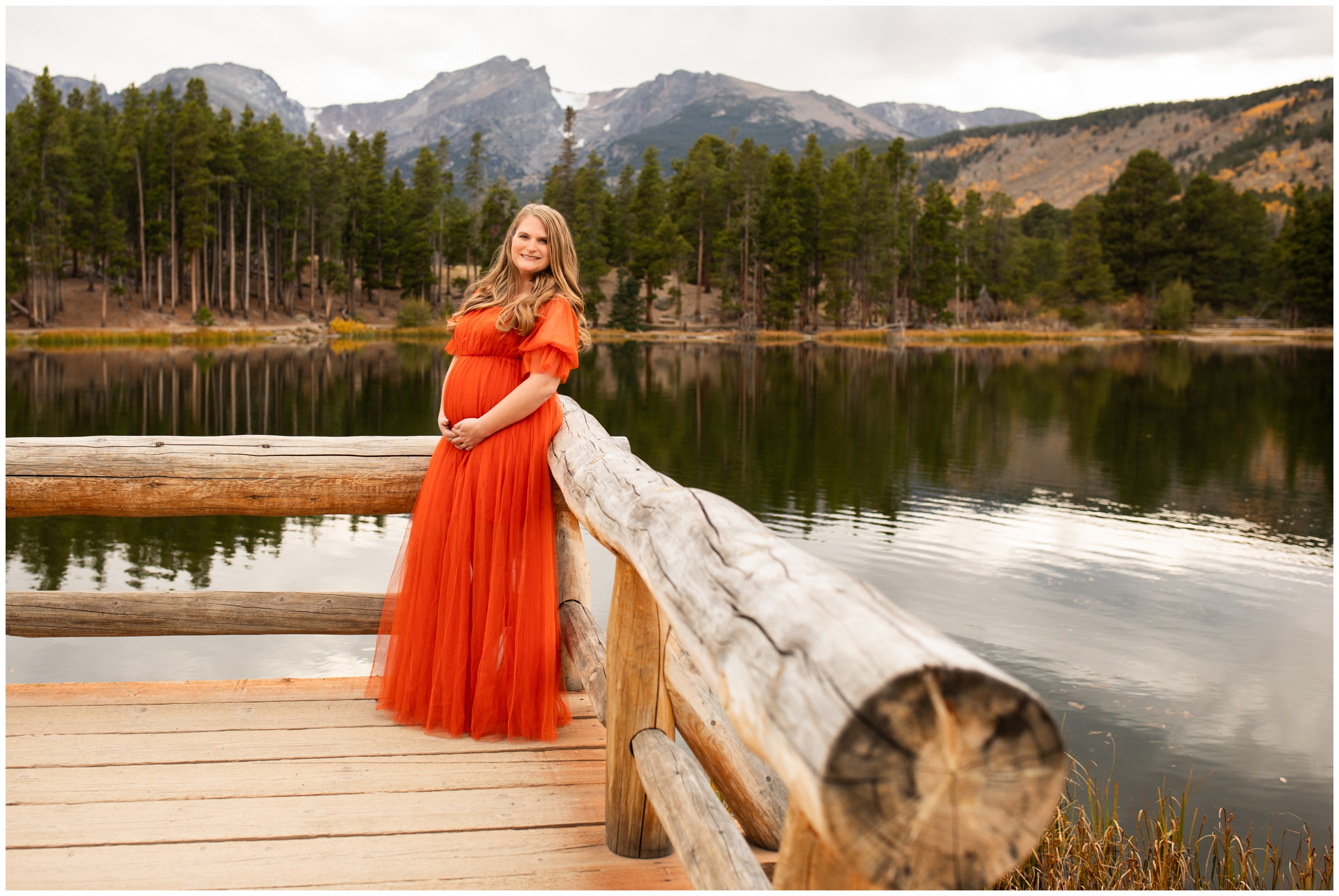 woman posing on dock at Sprague Lake during fall RMNP maternity pictures in Colorado 