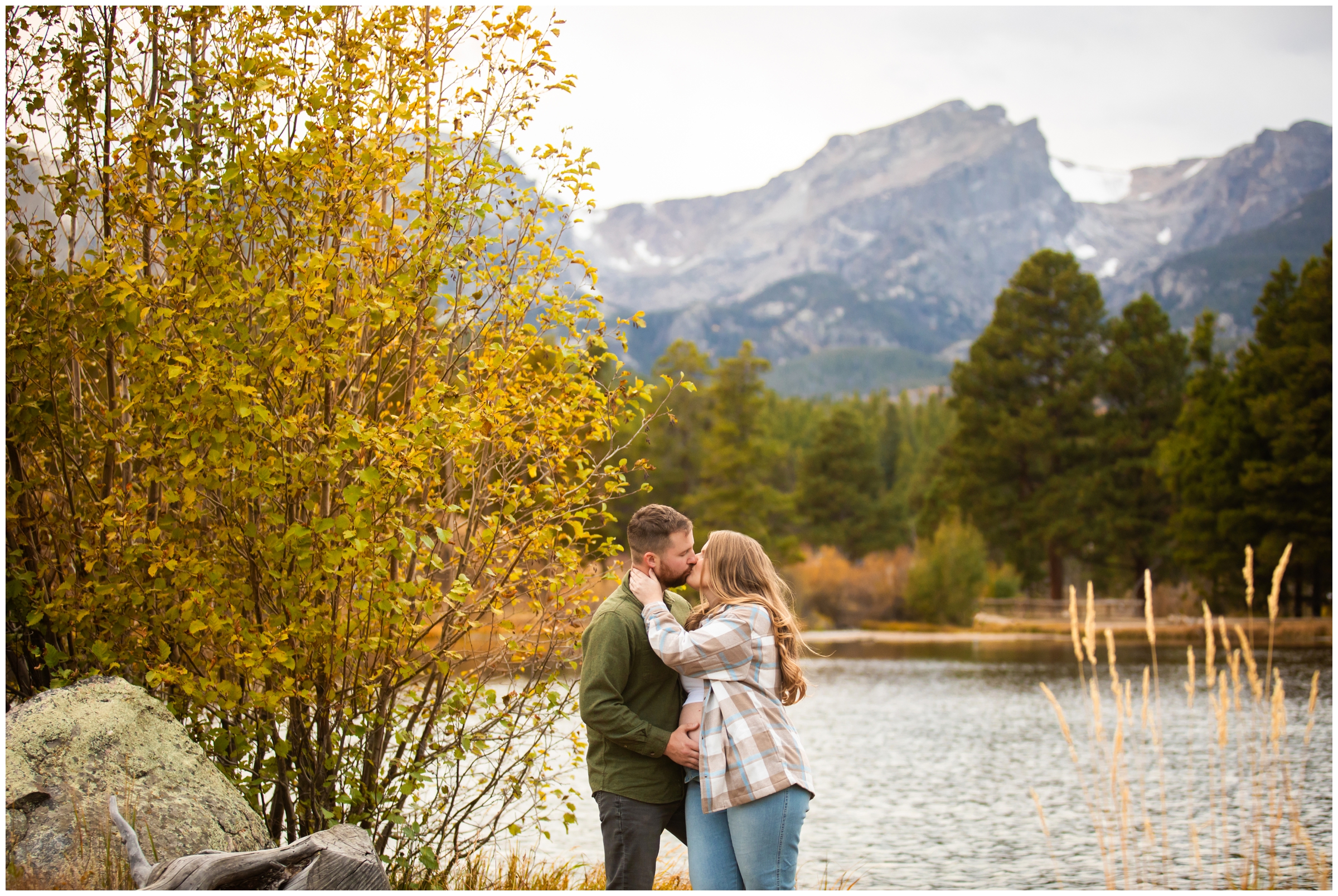 couple kissing in front of mountains during Sprague Lake RMNP maternity photos 