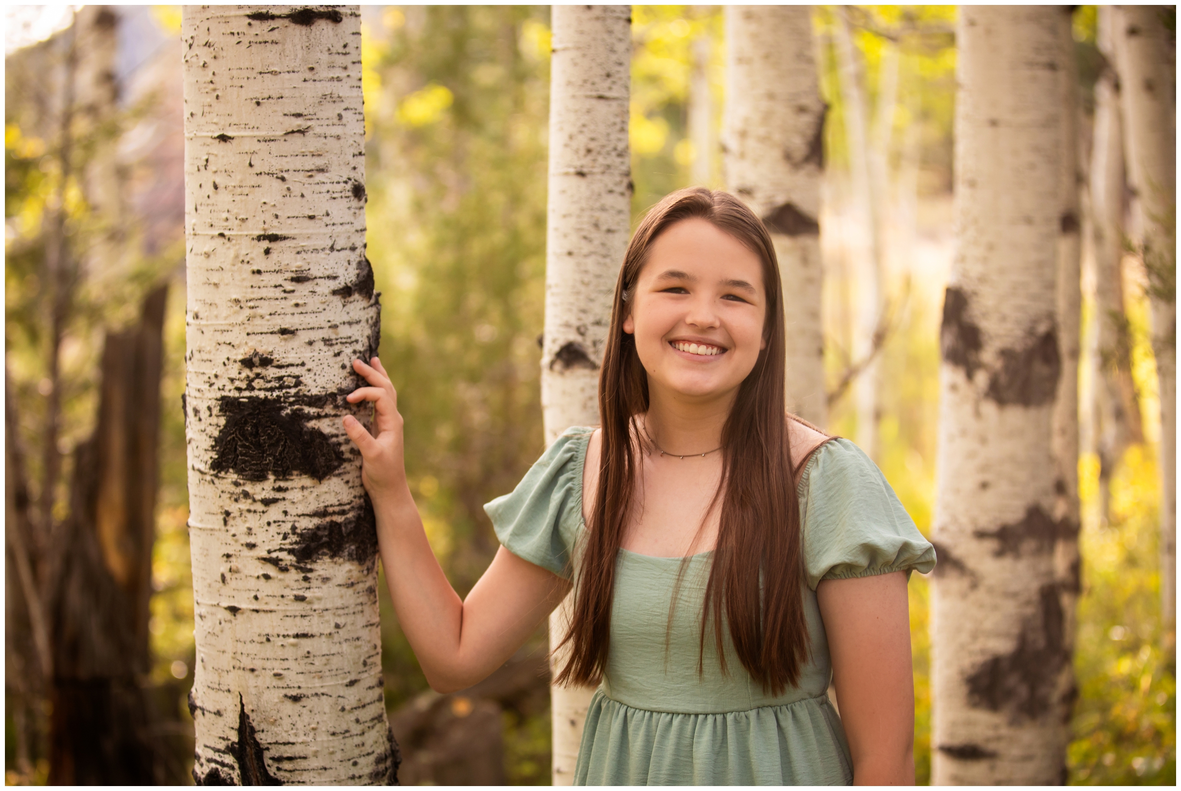 teen leaning against aspen tree during fall senior photos at Gross Reservoir Colorado 