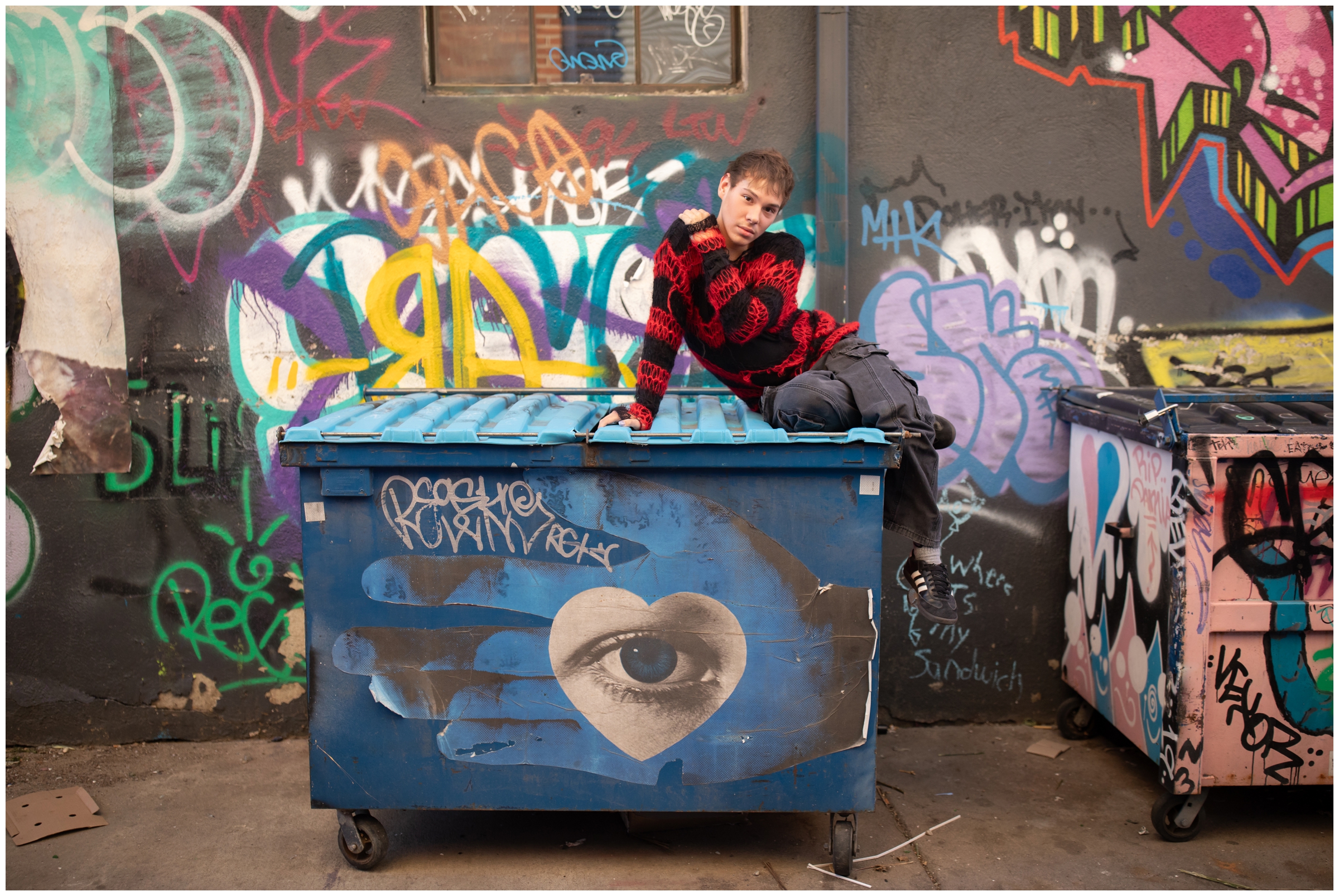 teen guy posing on trash bins during artsy Denver Colorado senior portraits 