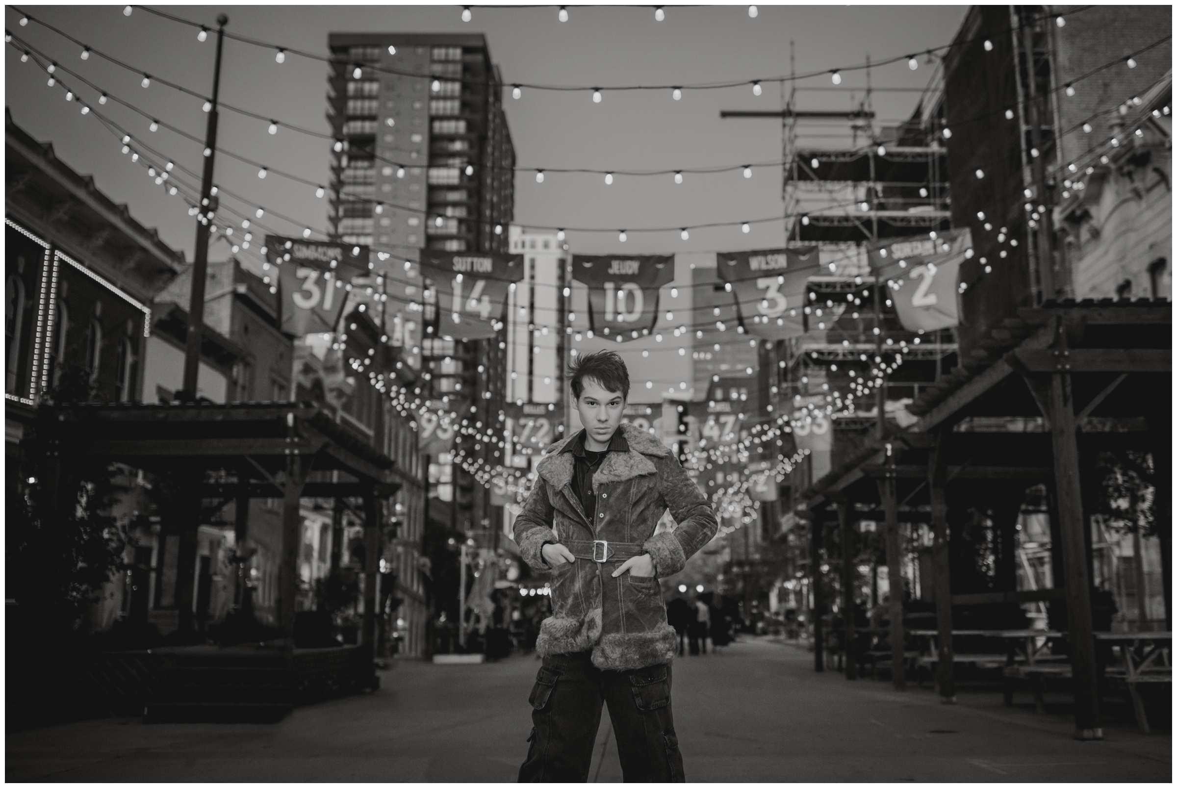 teen guy posing under the lights of Larimer Square during senior portraits in Denver Colorado 