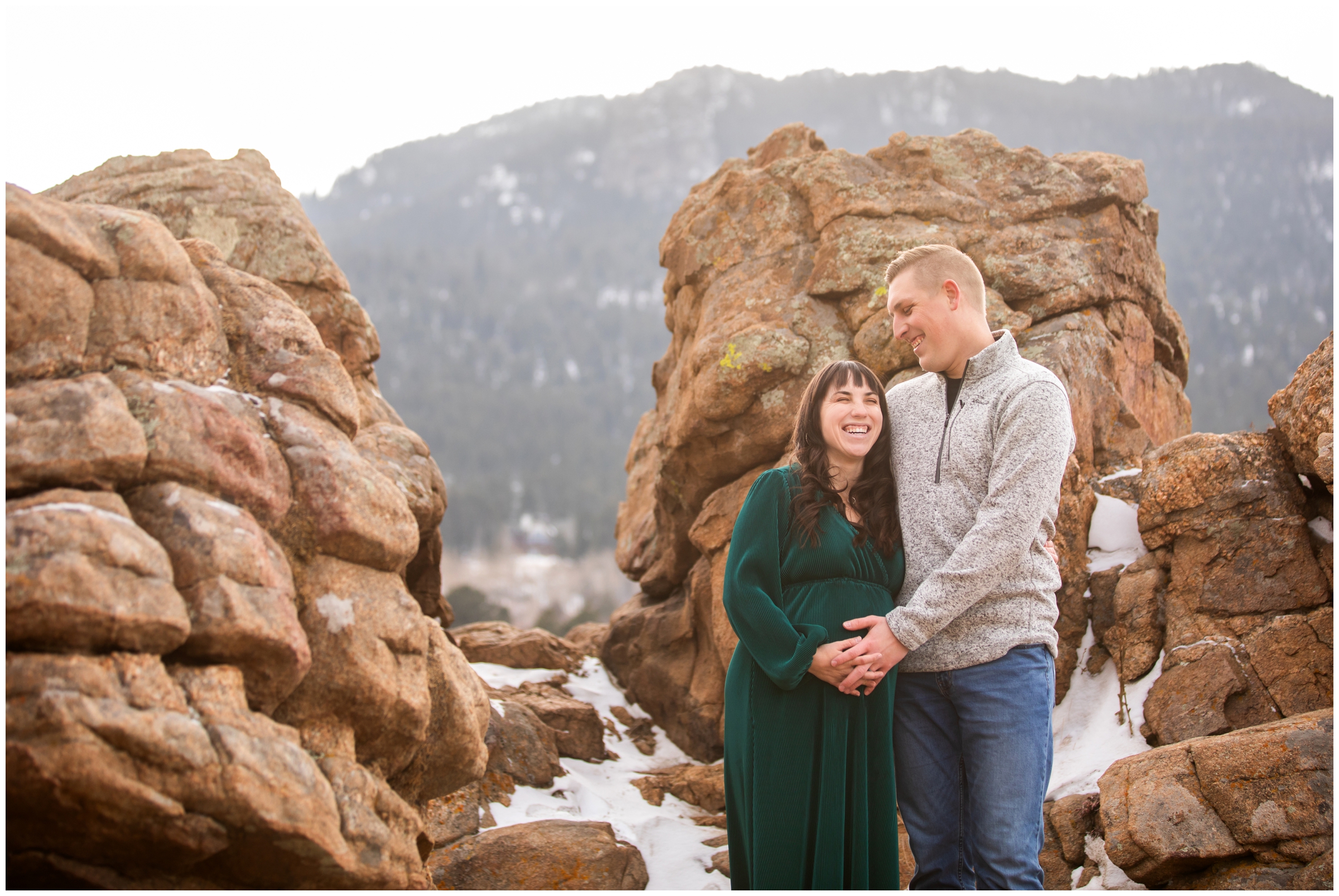 couple posing on rock formations at Mary's Lake during maternity portraits in Colorado mountains by Plum Pretty Photography 