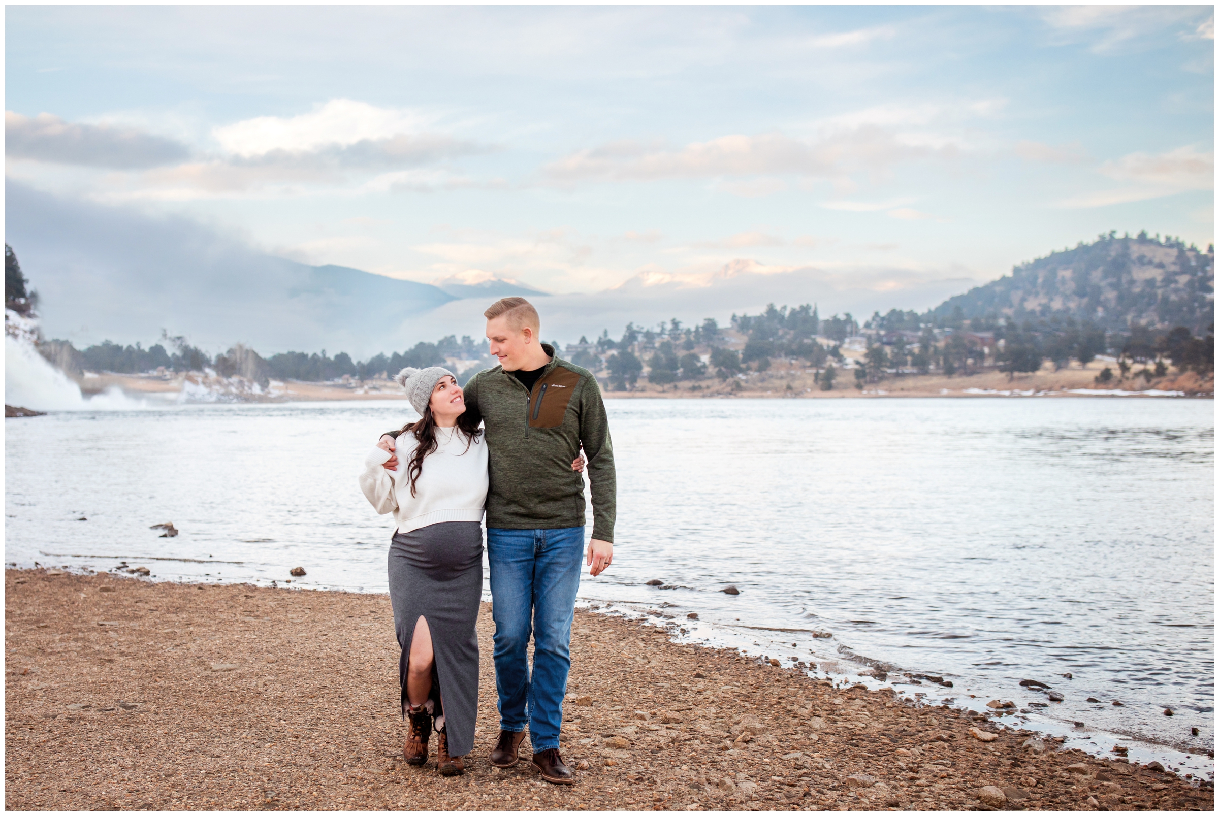 couple walking next to Mary's Lake during Estes Park winter maternity pictures by Plum Pretty Photography 