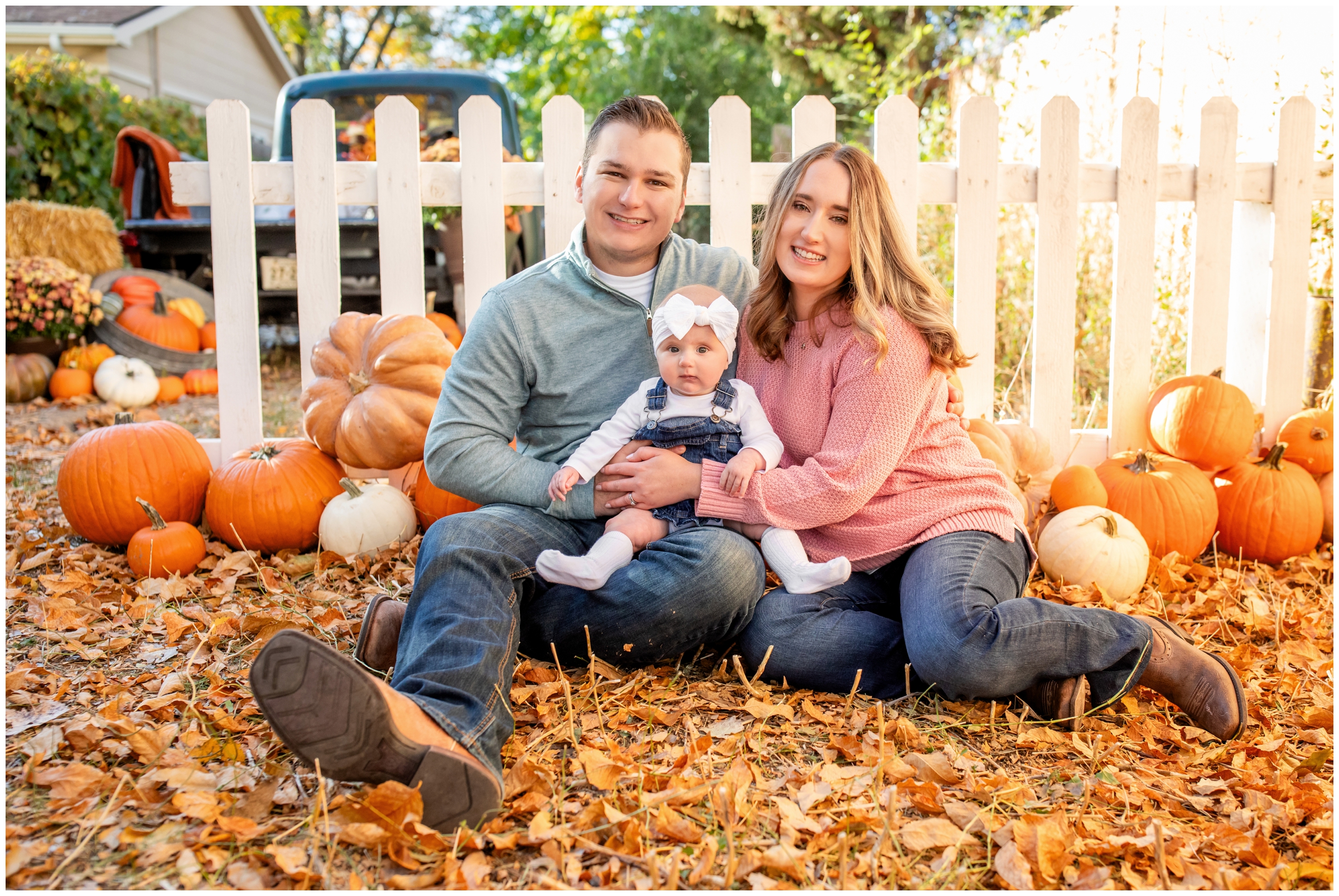 family sitting in a pile of leaves with pumpkins around during fall family mini sessions by Colorado portrait photographer Plum Pretty Photography 