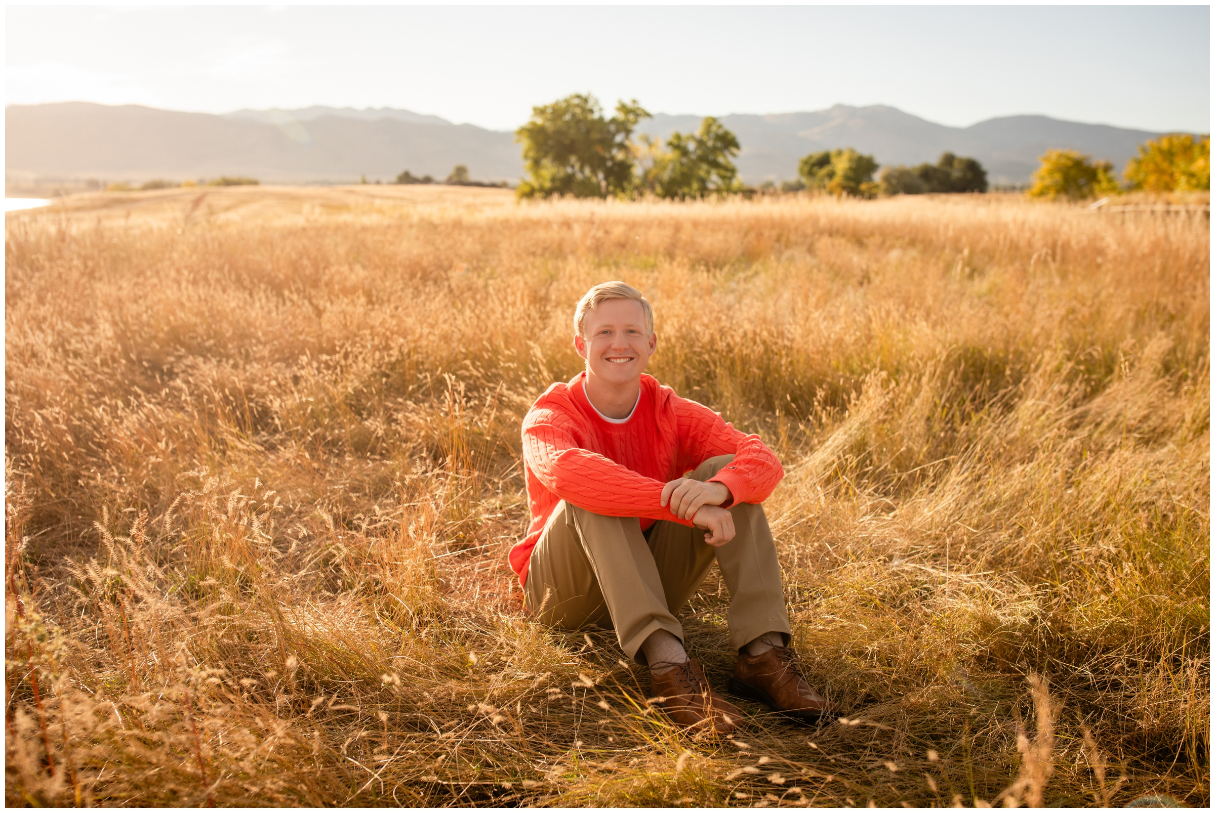 teen guy sitting in open field at Coot Lake during Frederick High senior photos by Plum Pretty Photography 