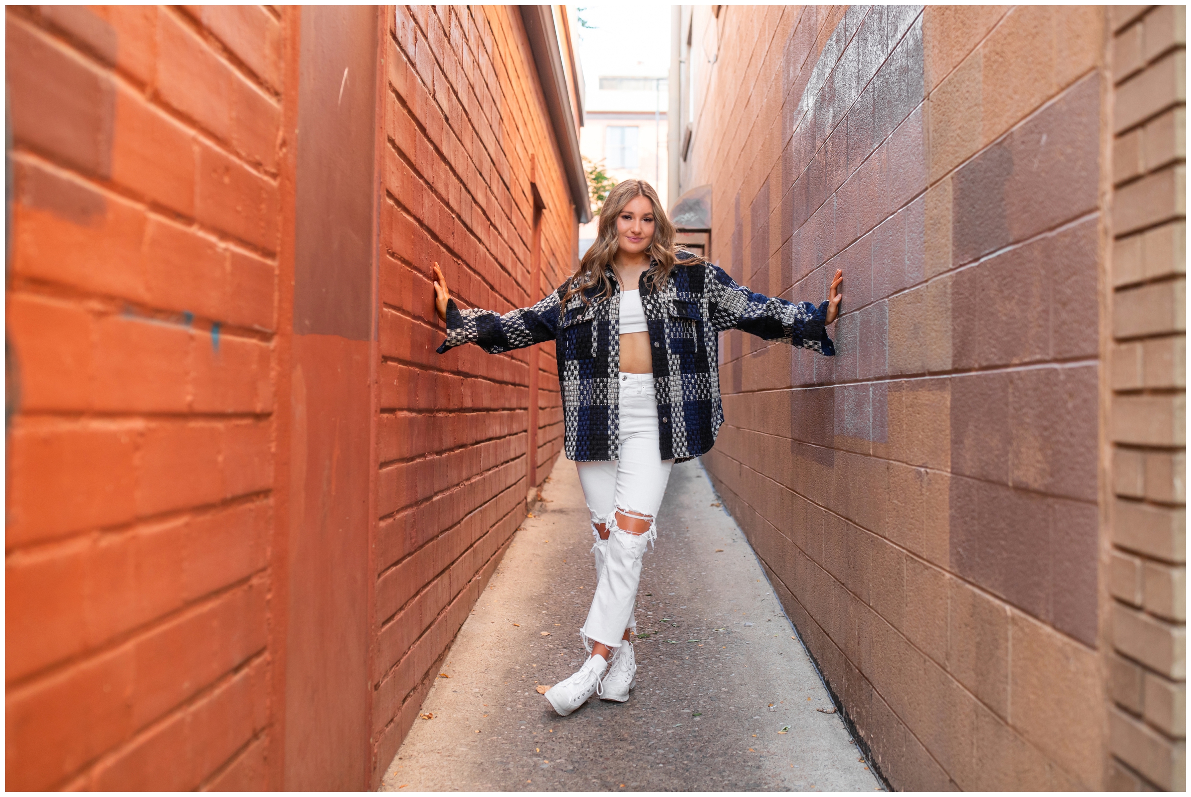 teen posing in alleyway in downtown Boulder during Holy Family High School senior portraits by Plum Pretty Photography 