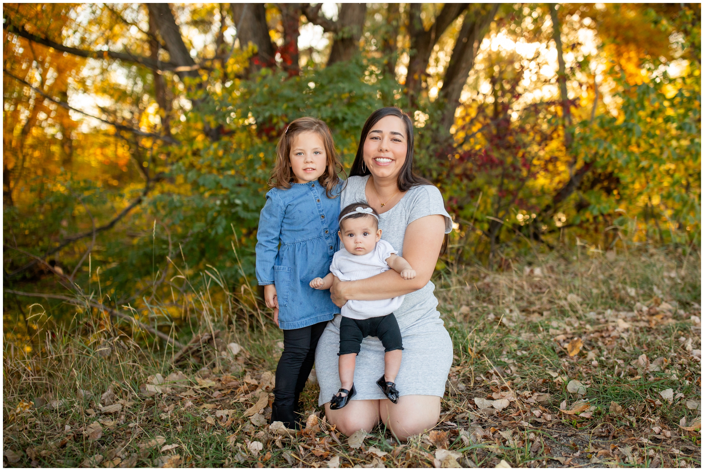 mom and daughters posing in front of fall foliage for Longmont Colorado family portraits