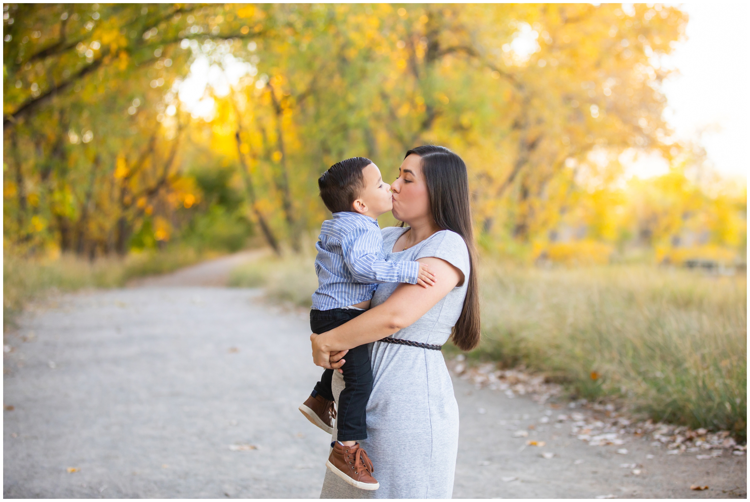 mom kissing her son during Longmont fall family photography session at Golden Ponds