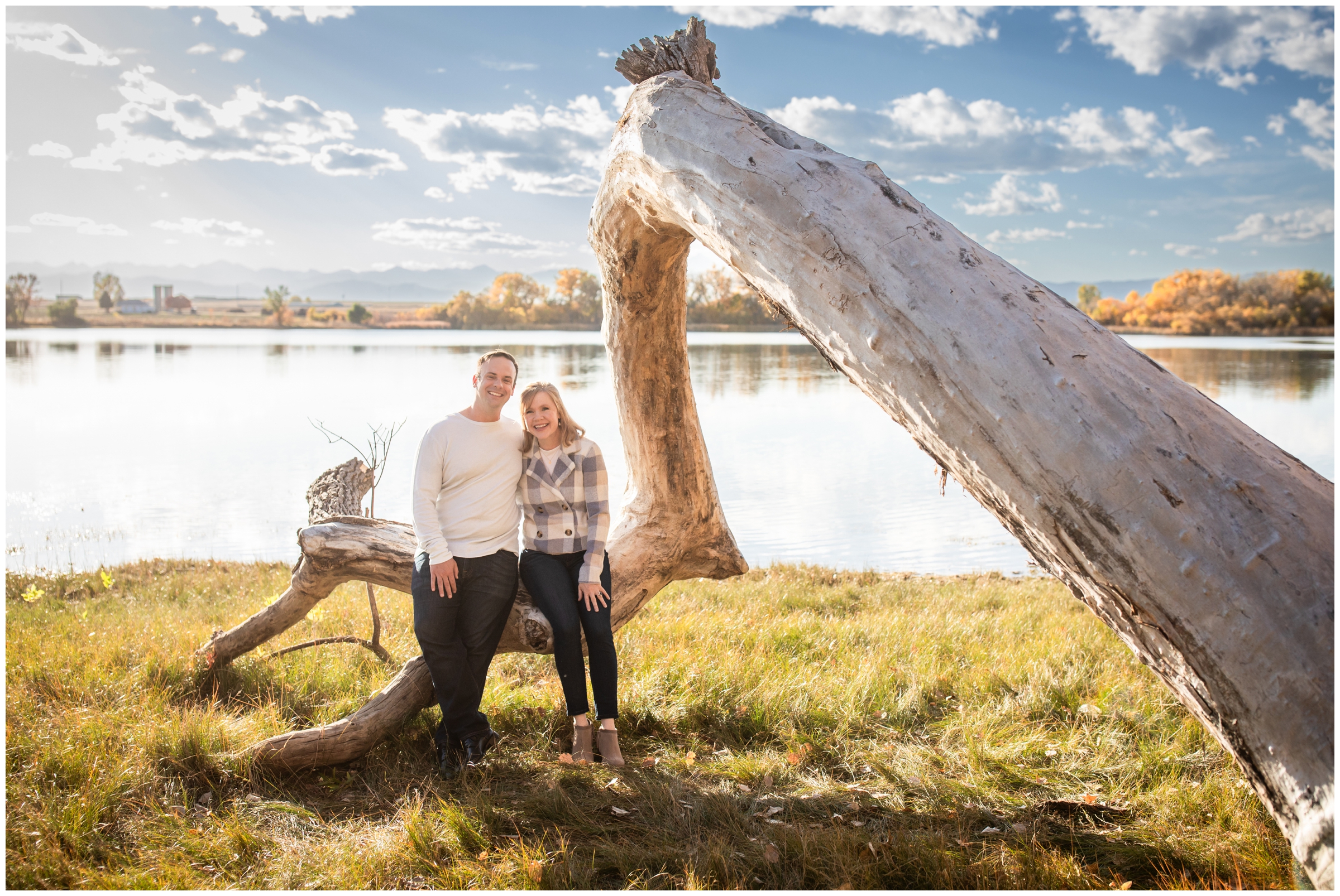 couple sitting on downed tree during unique couples photos in Mead Colorado 